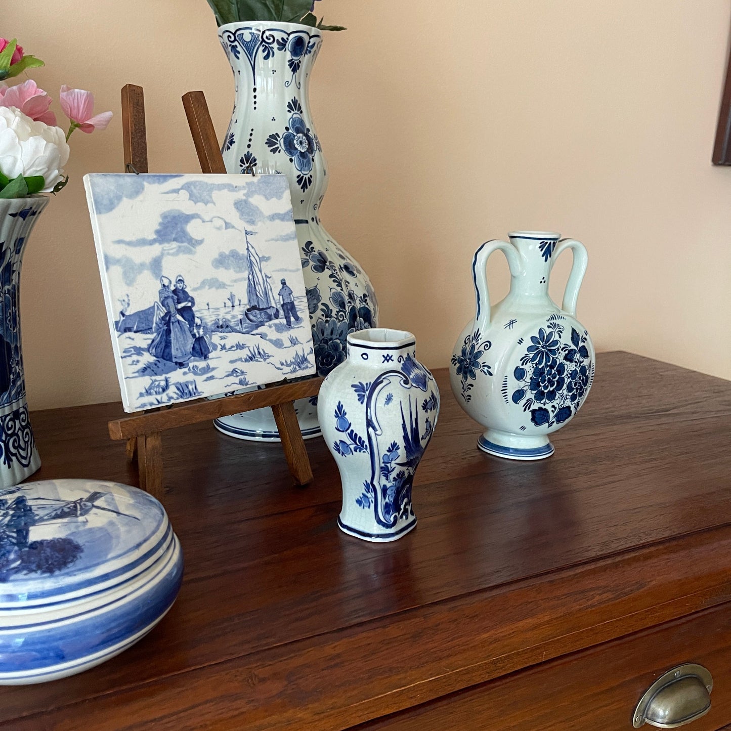 Collection of blue and white ceramic vases on a wooden surface with a neutral background