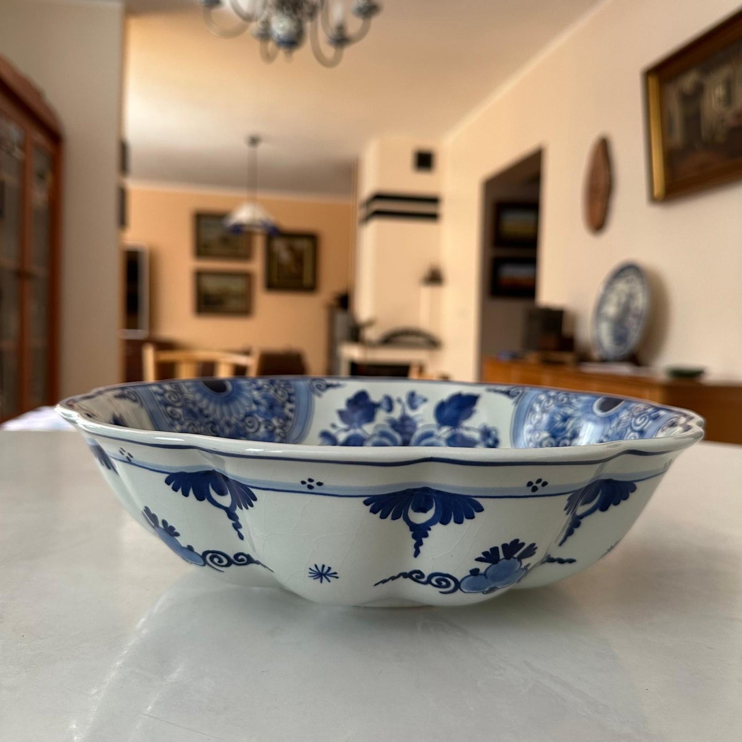 Blue and white ceramic bowl on a table with a blurred indoor setting