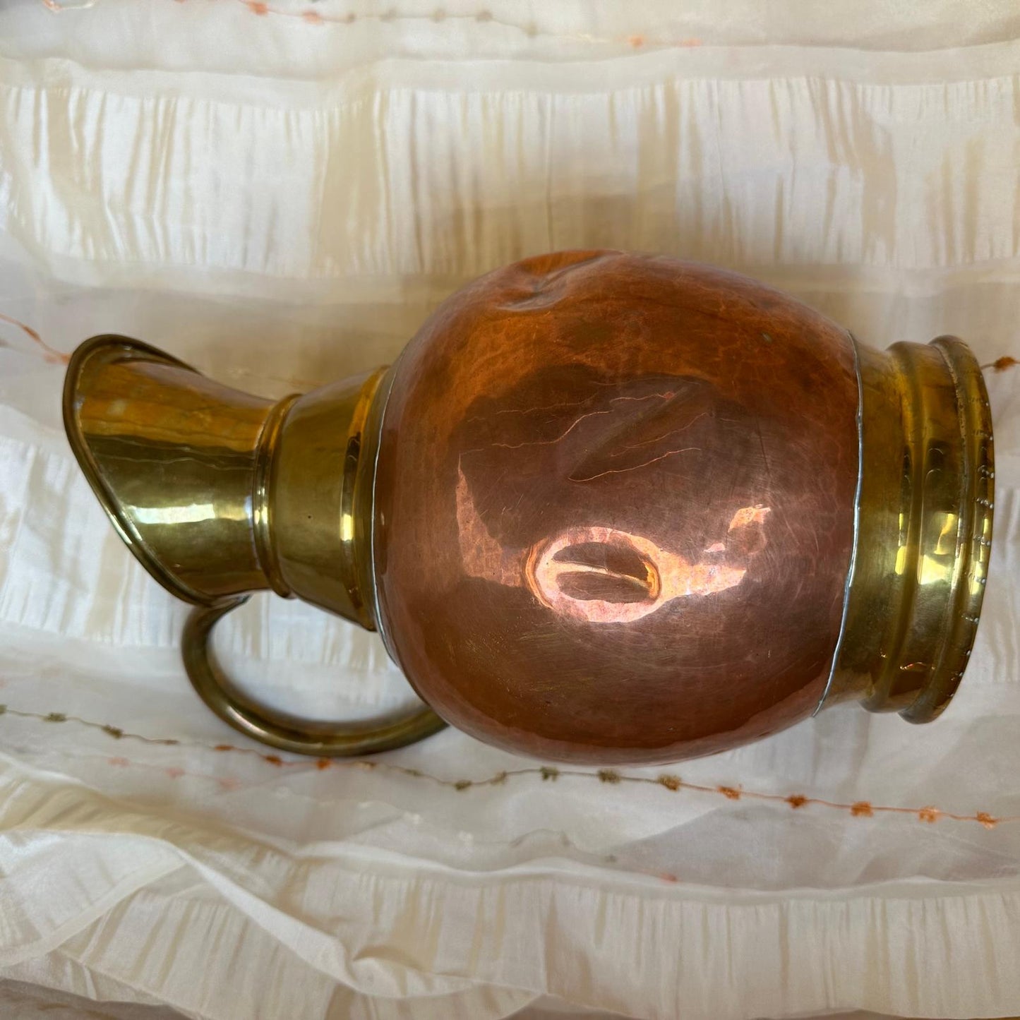 Copper and brass vase on a textured white background
