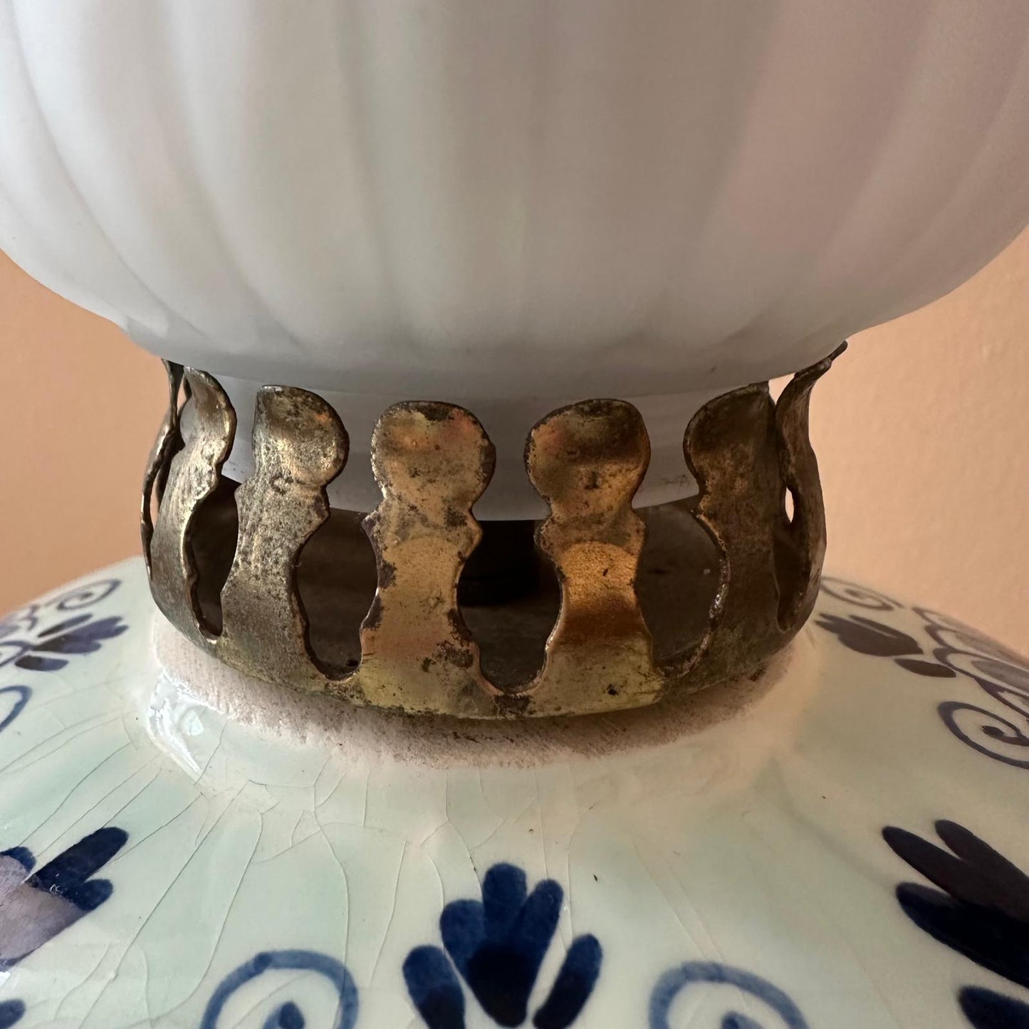 Close-up of a white ceramic item with a gold decorative base on a patterned surface.