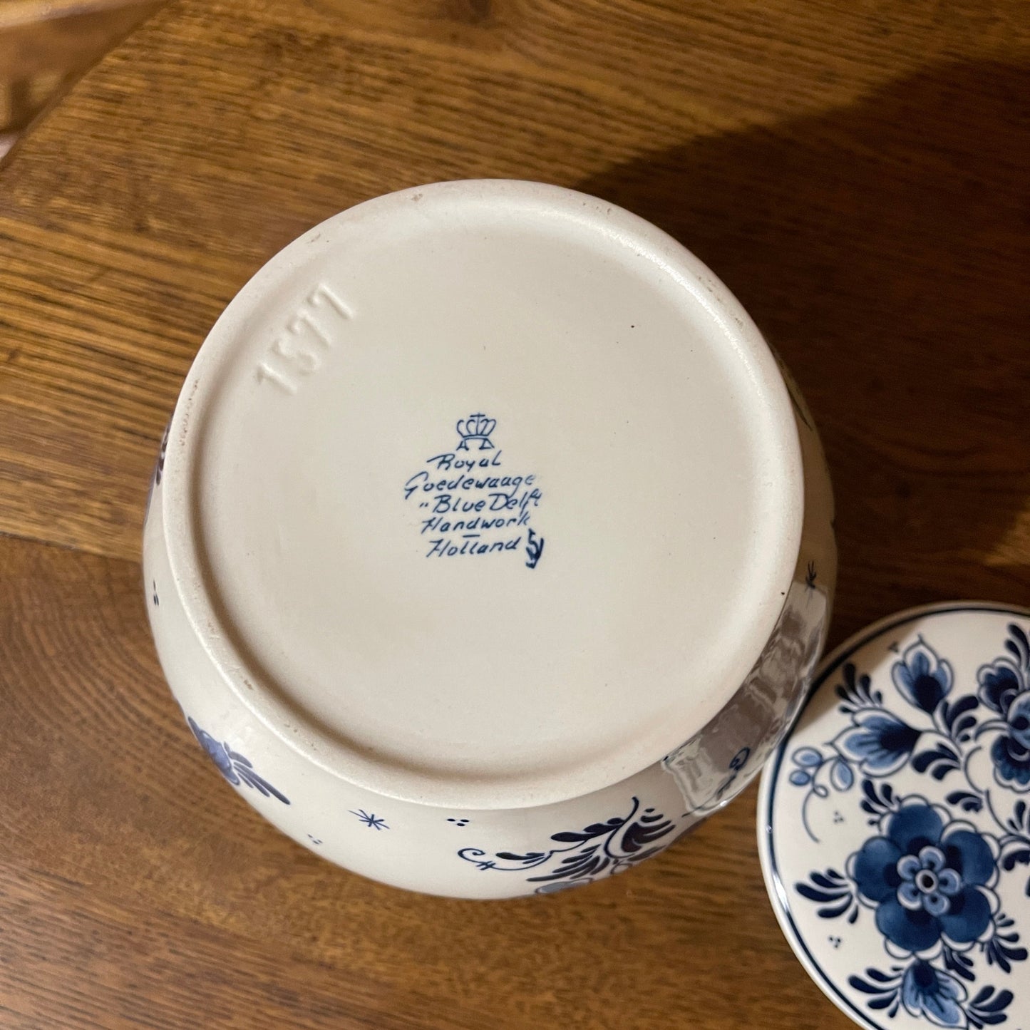 Delft blue ceramic jar with floral patterns on a wooden surface