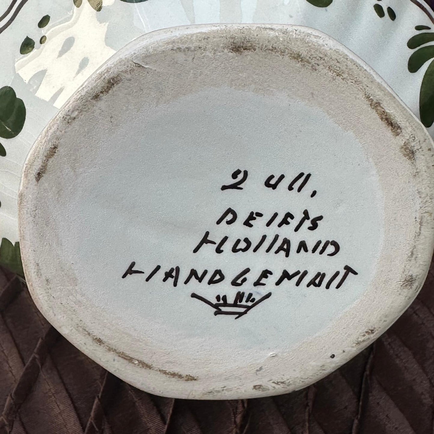 Ceramic plate with handwritten text on a textured surface