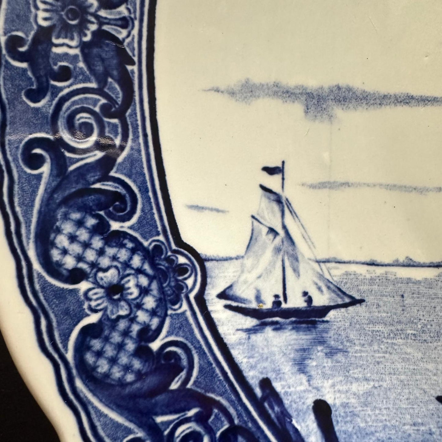 Blue and white ceramic tile with a sailboat design
