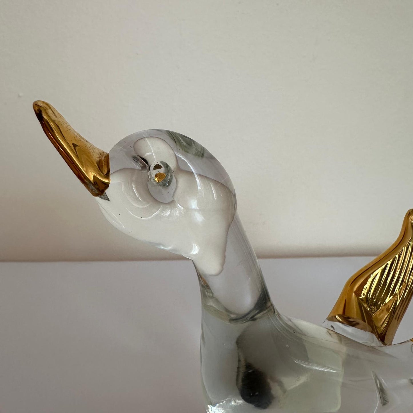 Decorative glass duck with gold accents on a white background