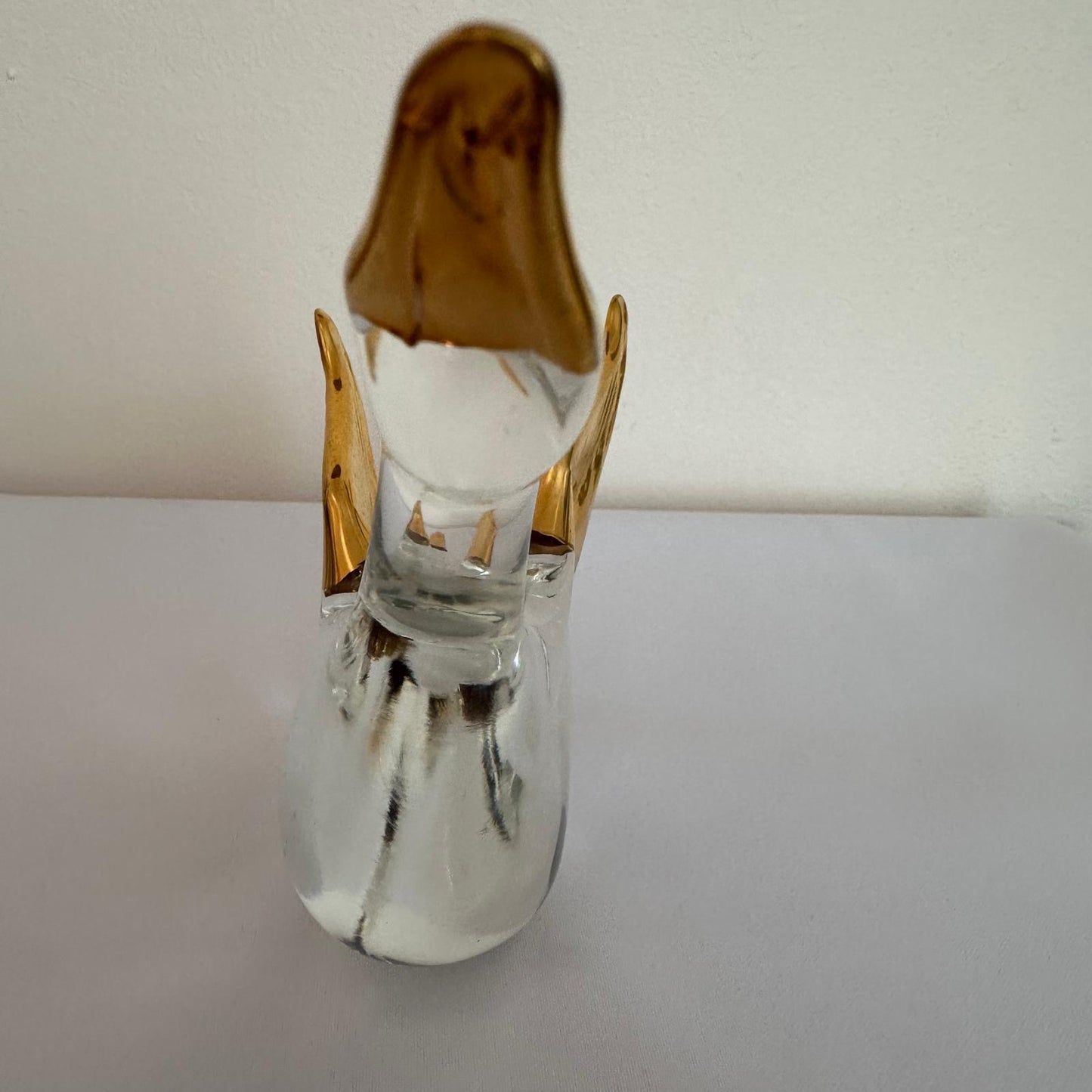 Clear glass object with gold accents on a white background