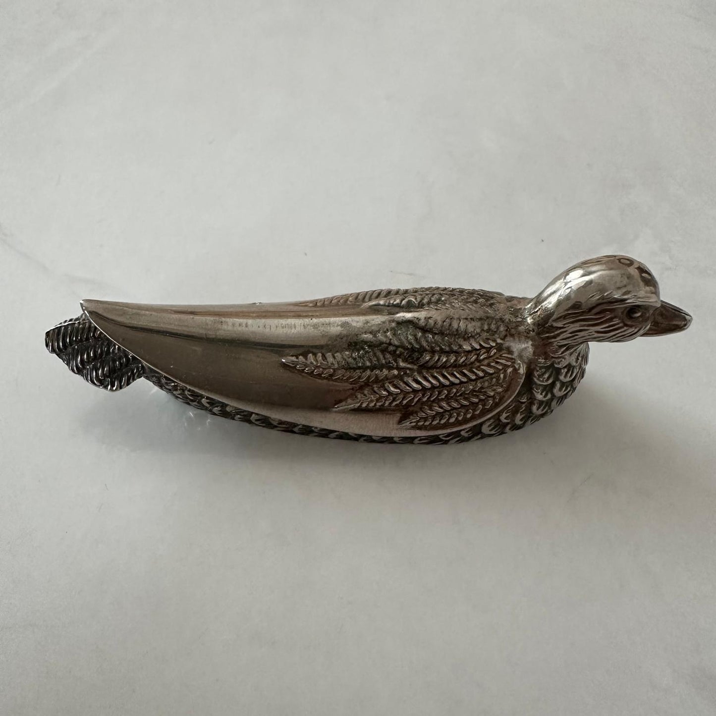 Metallic duck-shaped object on a white background