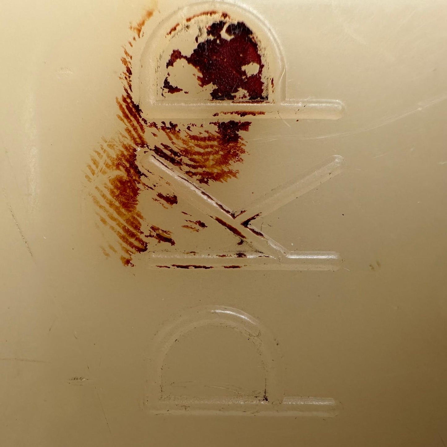 Stained plastic with a figure of a person holding a gun on a beige background