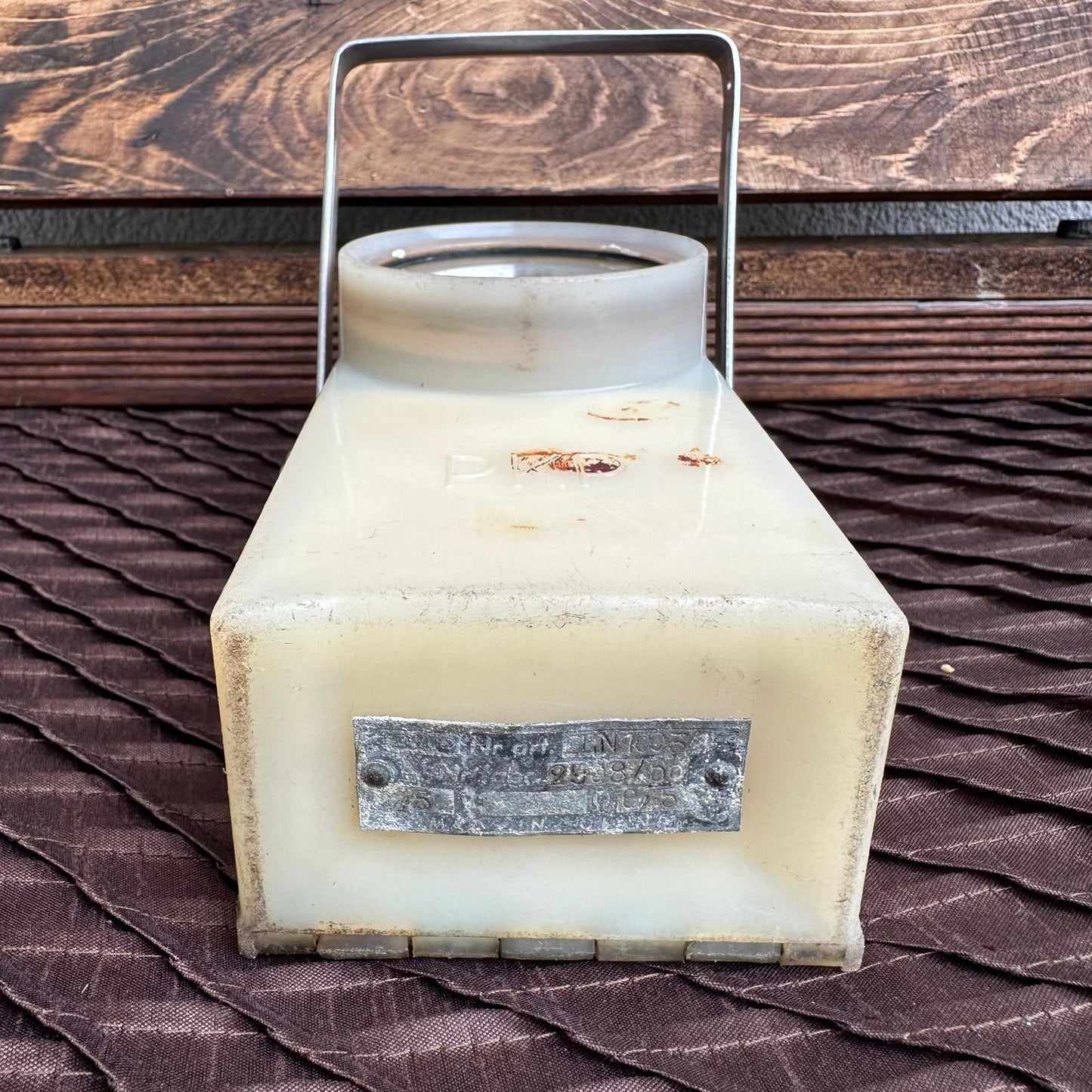 Vintage-style lantern with a metal handle on a textured surface