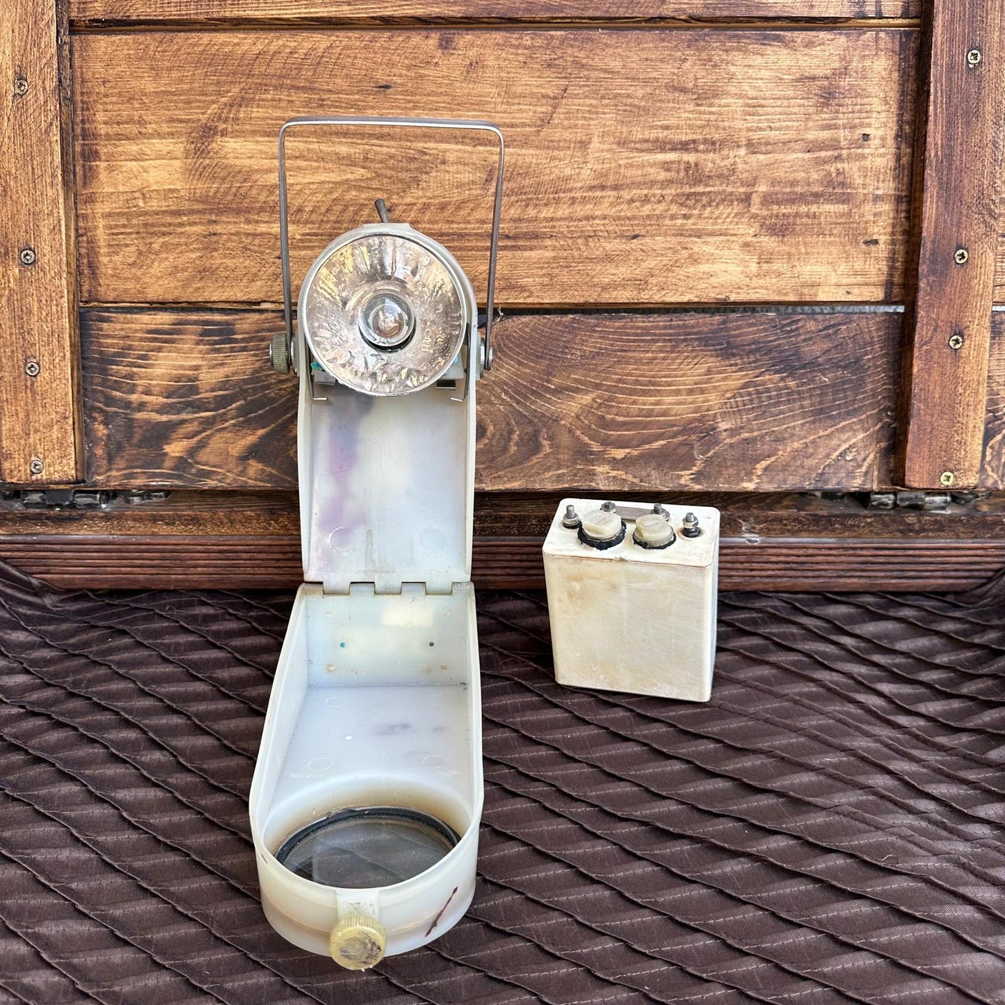 Vintage-style lantern on a wooden surface with a battery pack in the background.