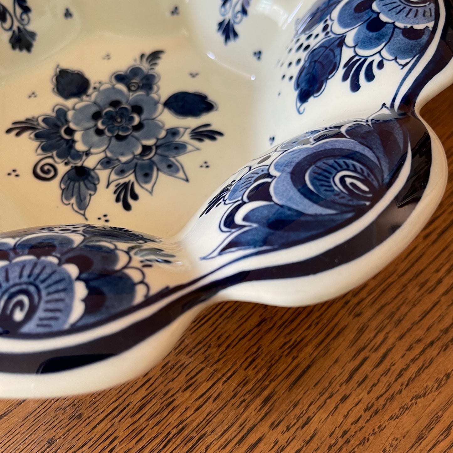 Blue and white floral-patterned ceramic spoon rest on a wooden surface