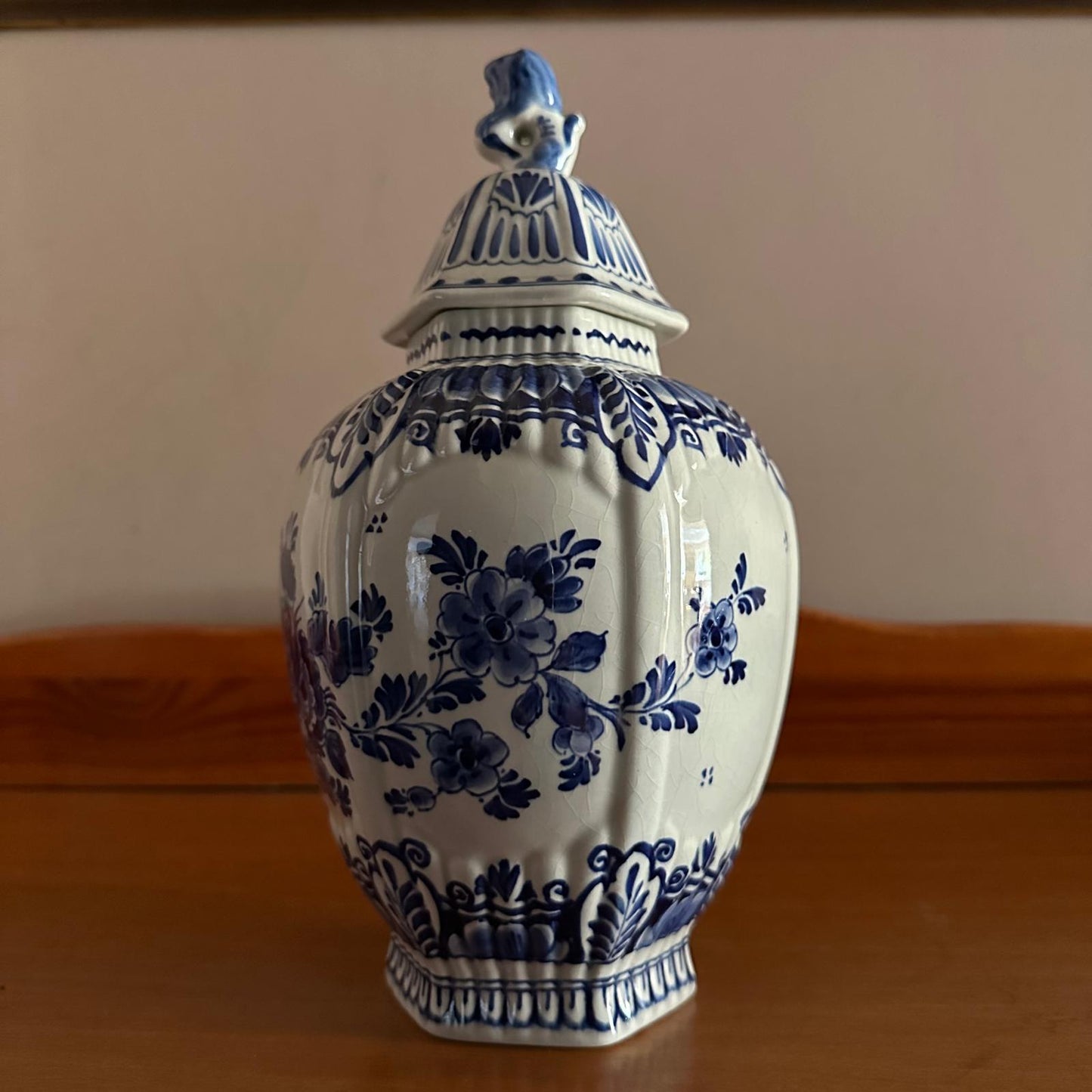 Blue and white ceramic jar with floral patterns on a wooden surface