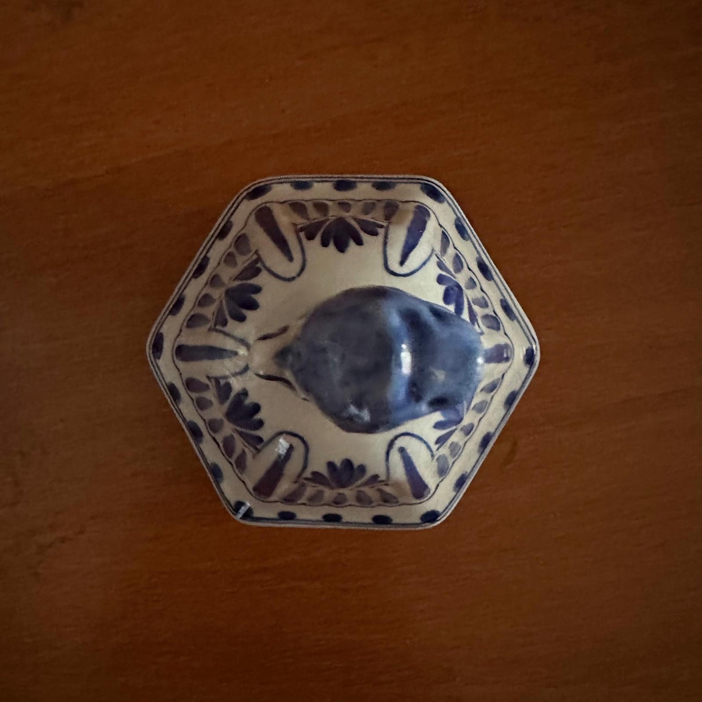 Hexagonal ceramic dish with blue floral patterns on a wooden surface