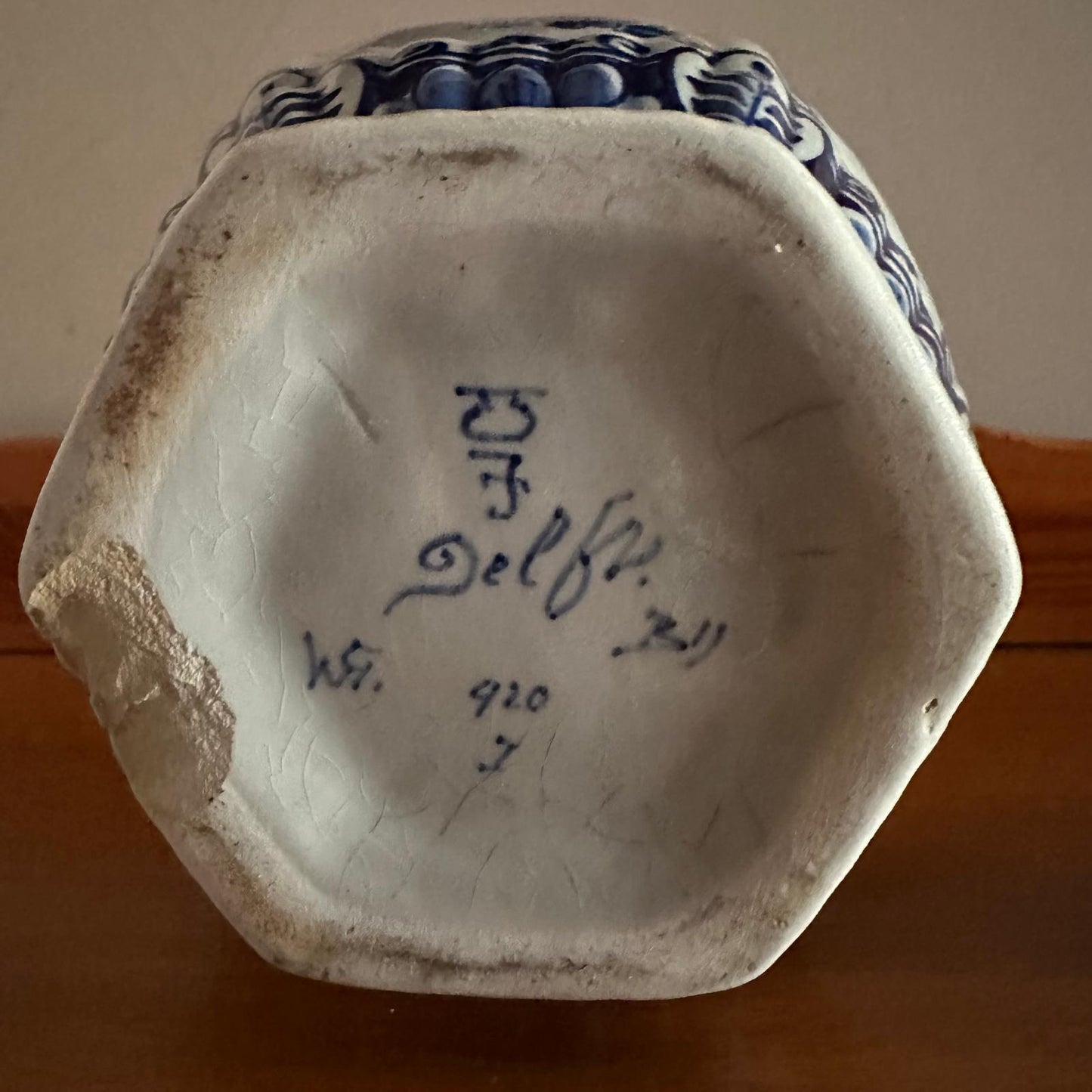 Ceramic vase with 'Delft' inscription on a wooden surface