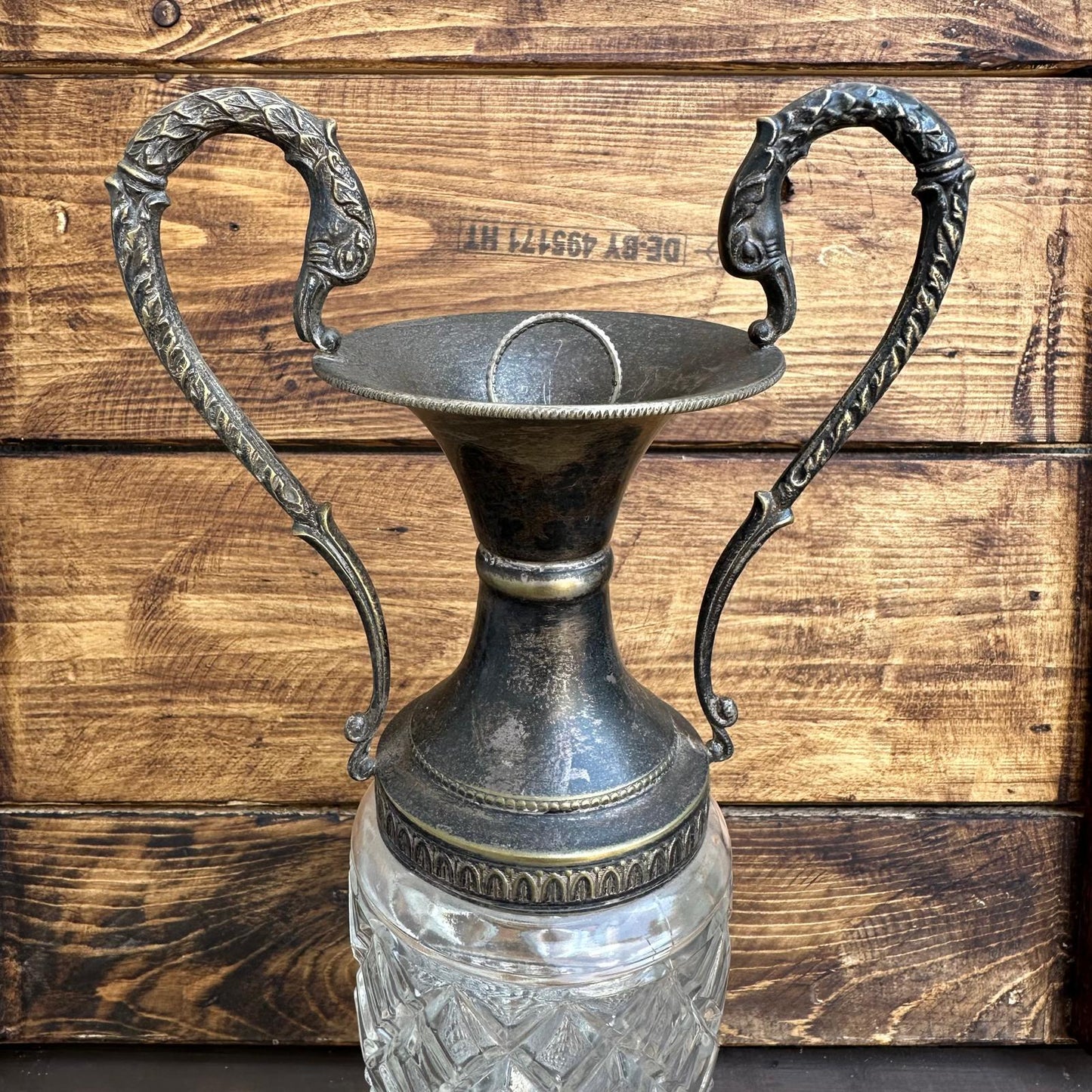 Decorative vase with ornate handles on a wooden background