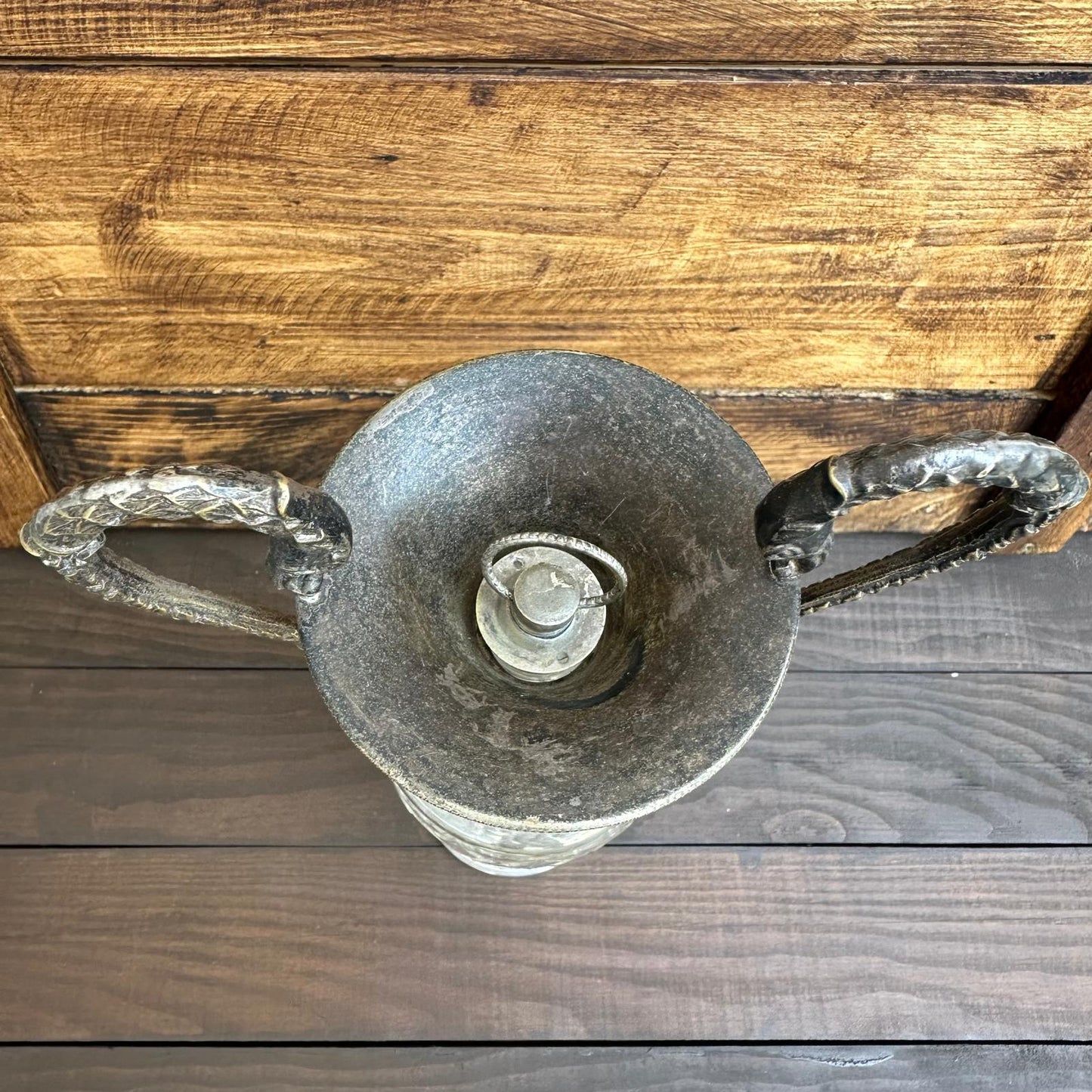 Decorative glass piece with handles on a wooden surface