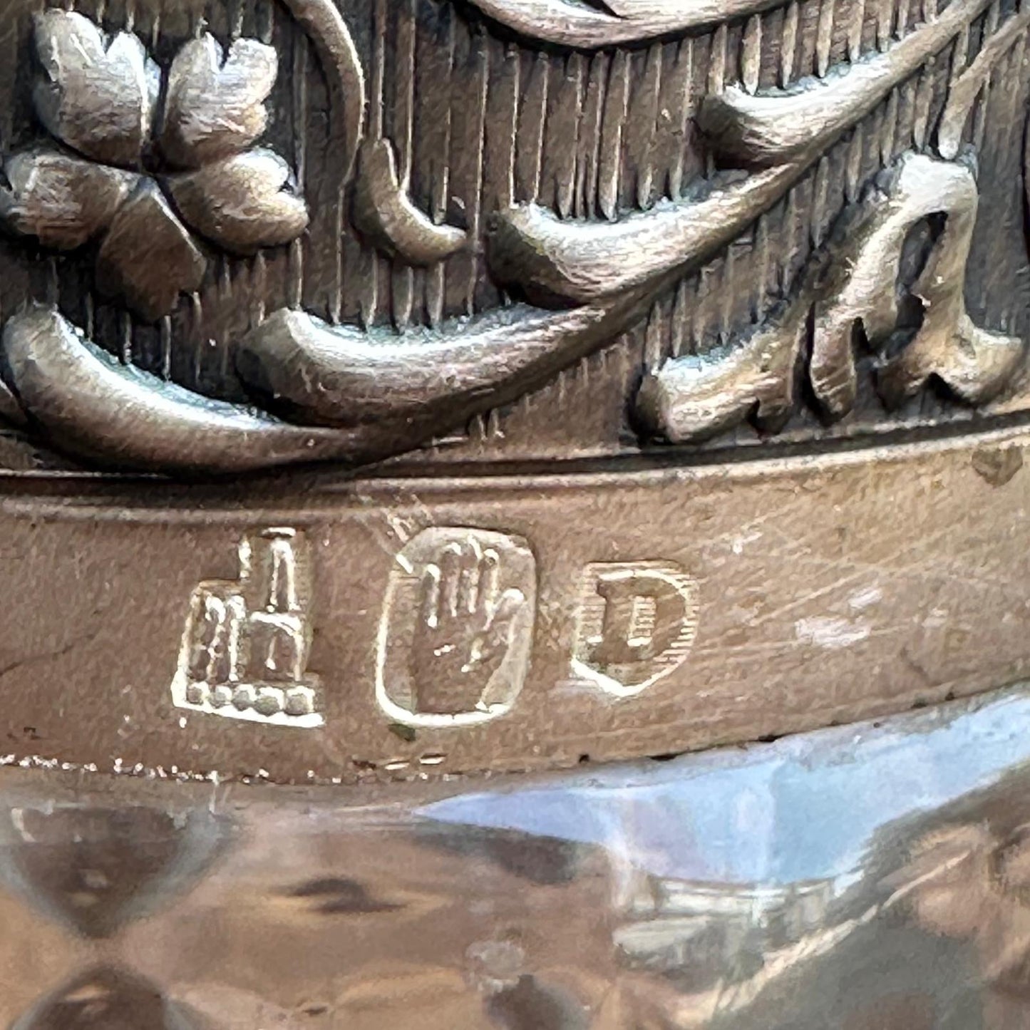 Close-up of a metallic object with engraved design and visible branding.