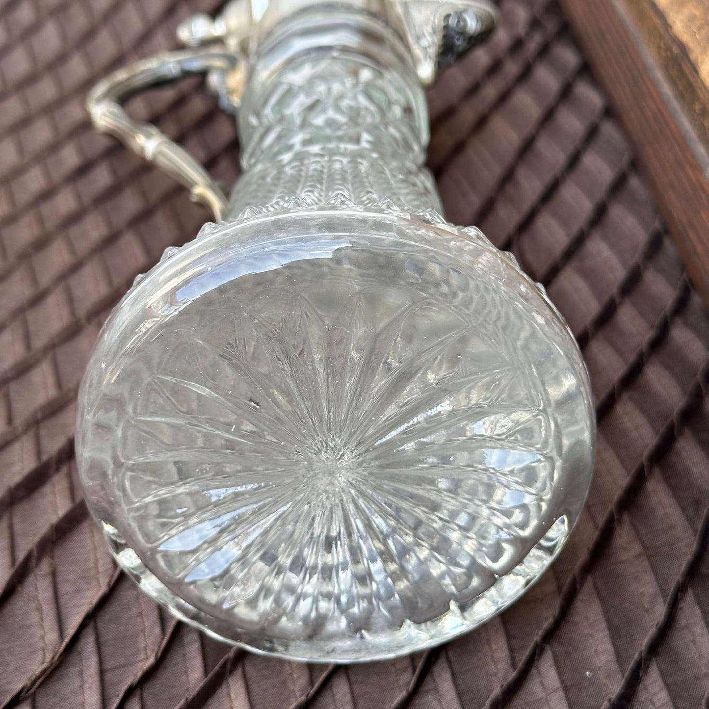 Clear glass object with textured base on a brown textured surface