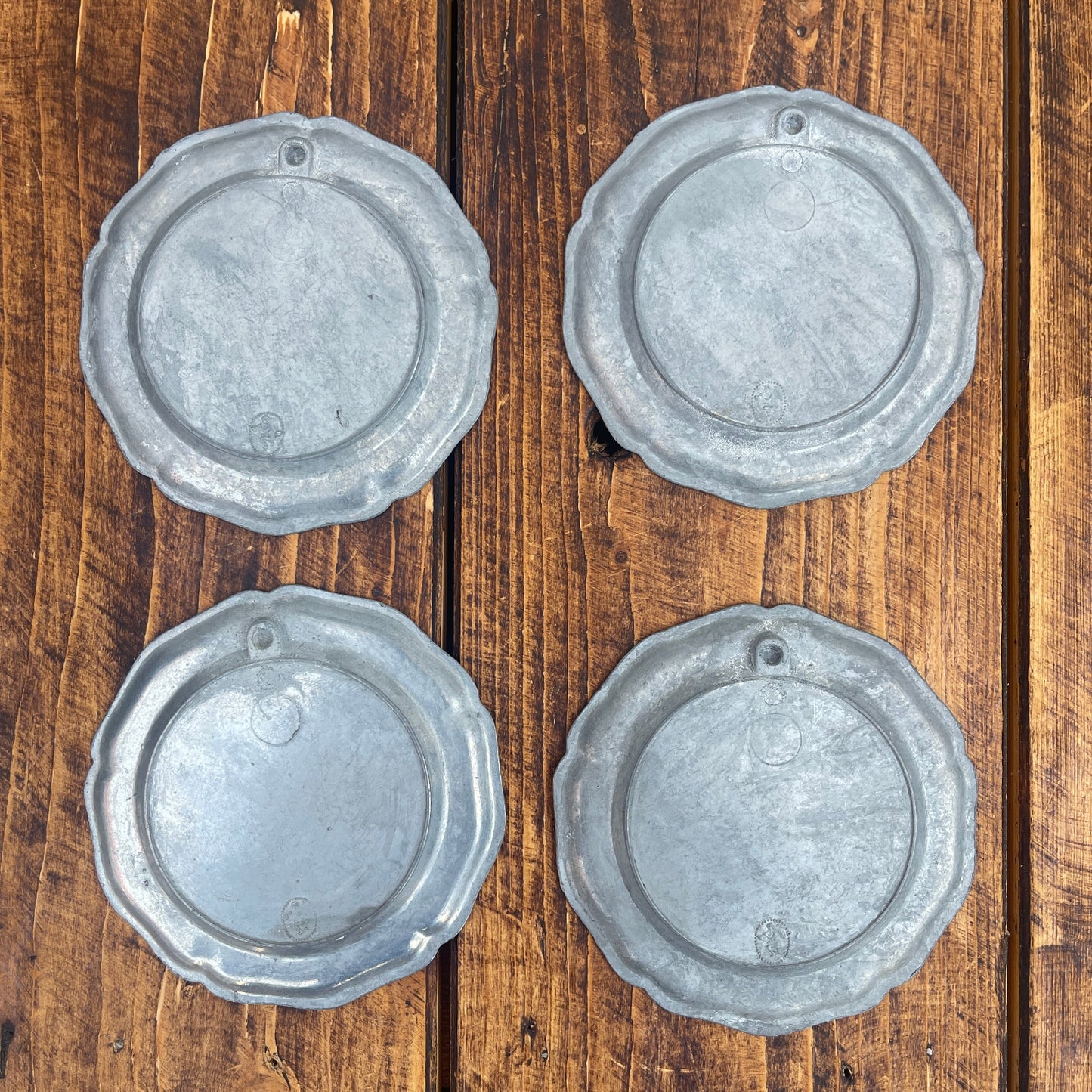 Four metallic circular objects on a wooden surface