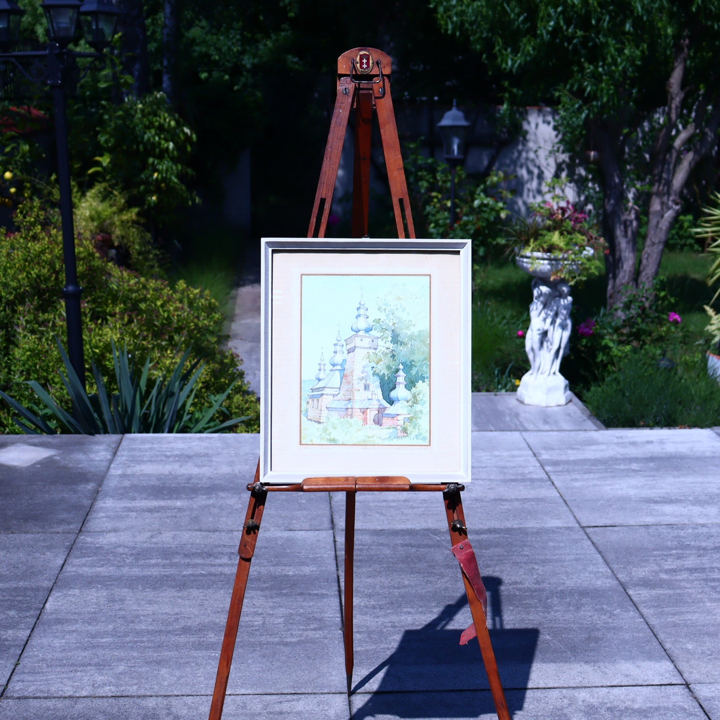 Framed artwork on an easel in a garden setting