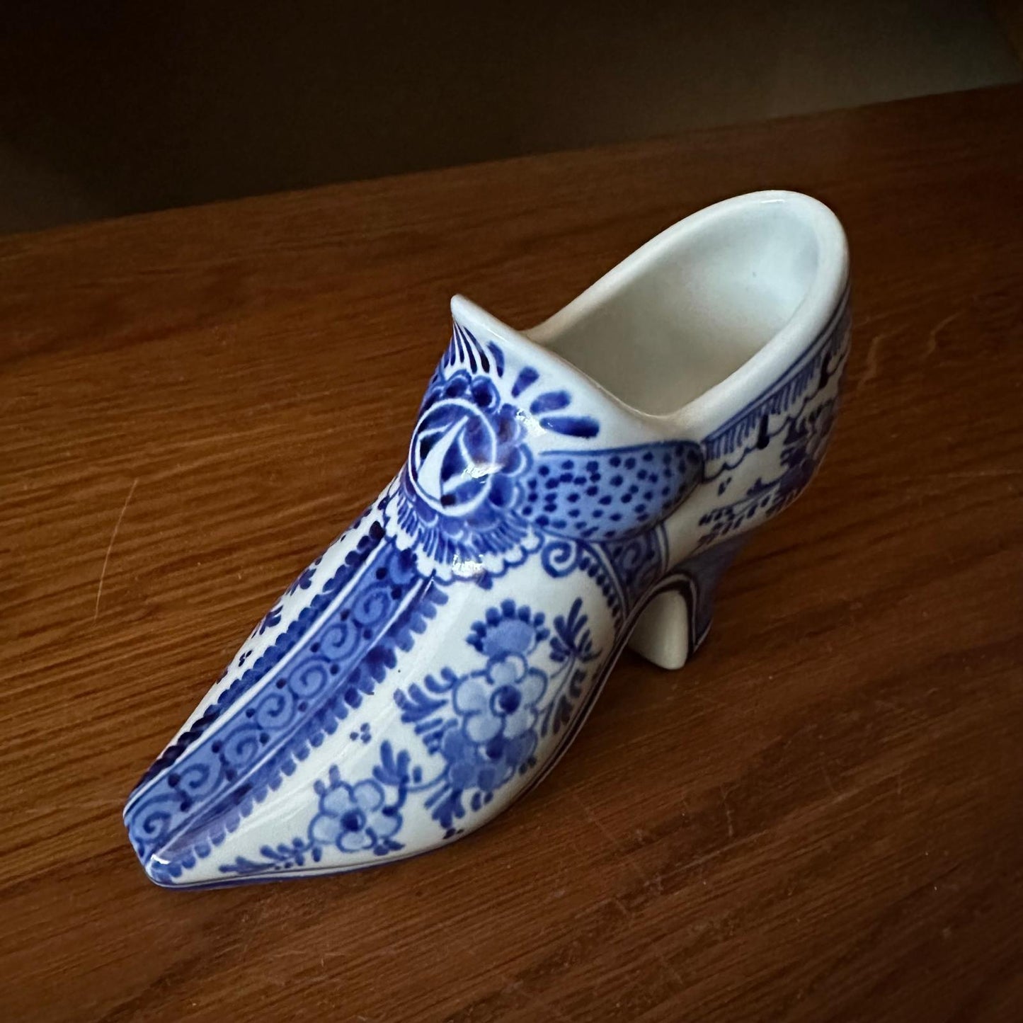Blue and white ceramic shoe on a wooden surface