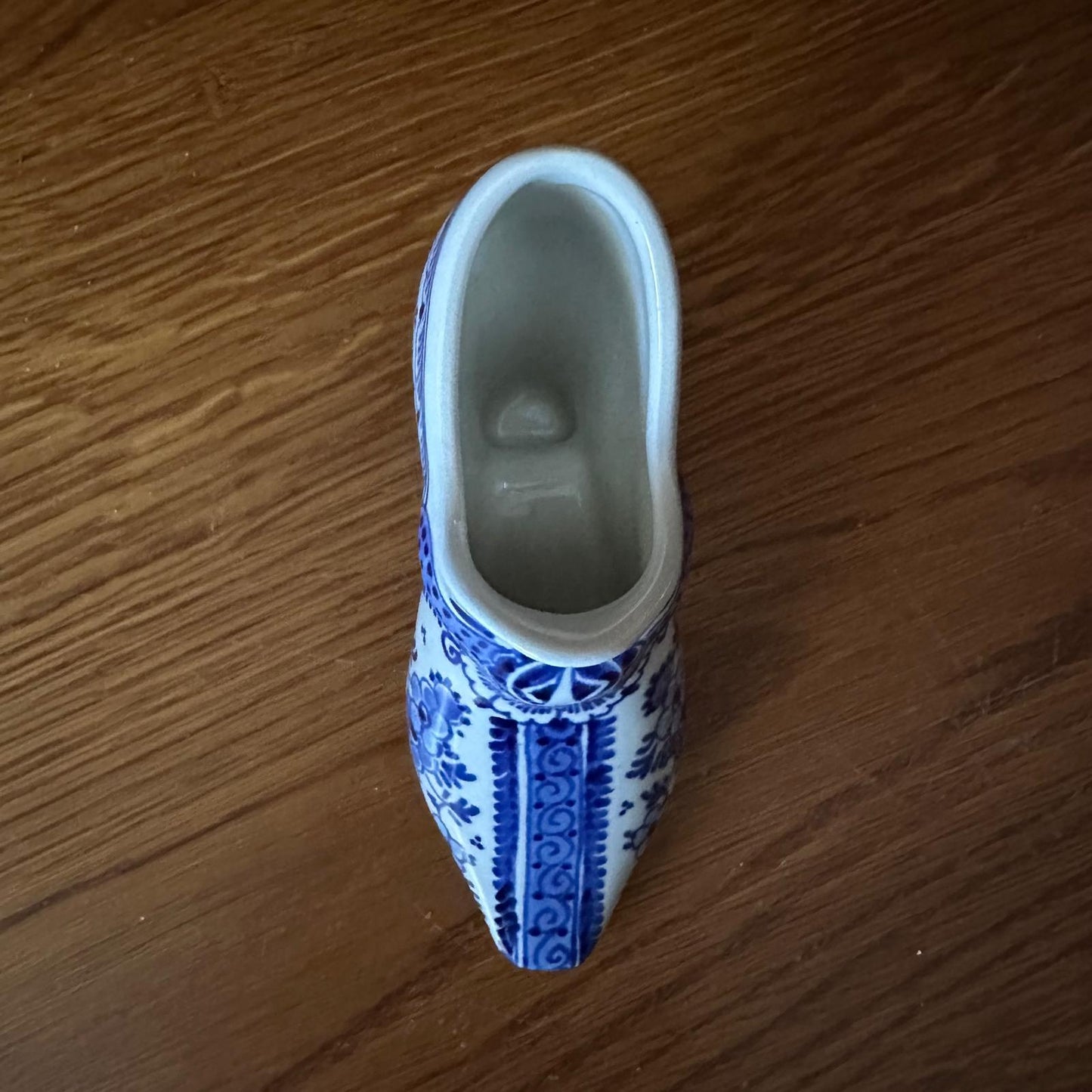 Blue and white ceramic clog on a wooden surface