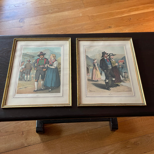 Two framed prints of historical figures on a wooden surface