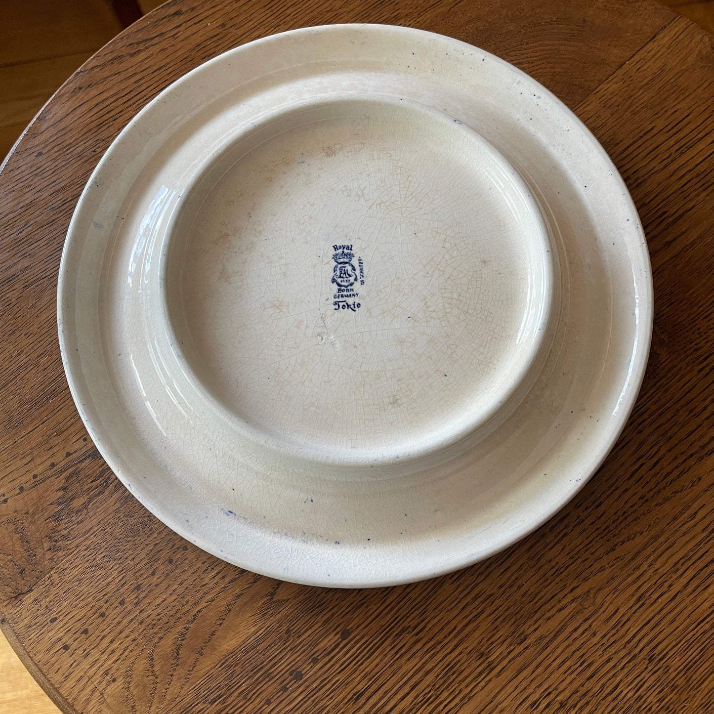 White ceramic plate with a logo on a wooden surface