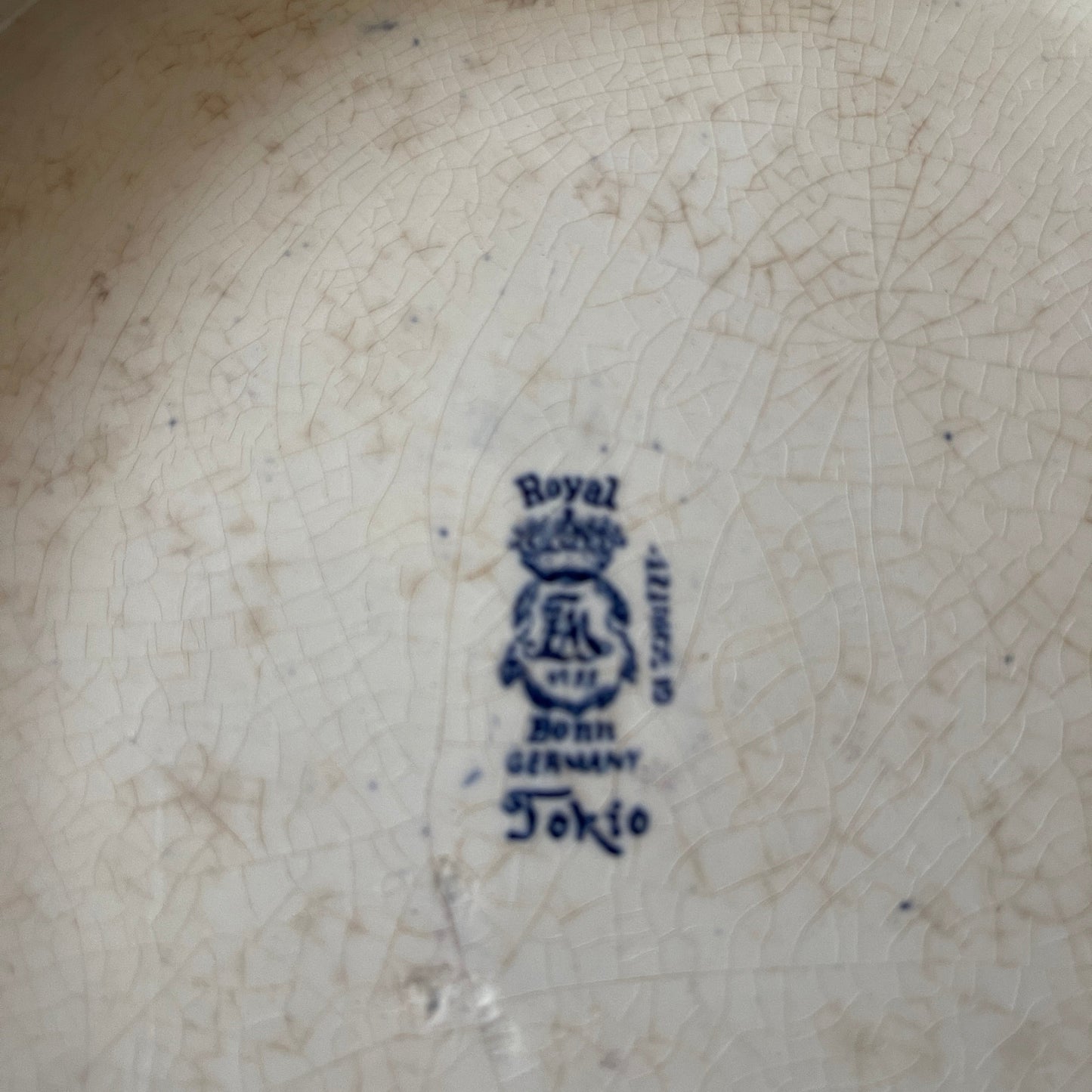 Royal Bonn logo on a ceramic plate with visible wear