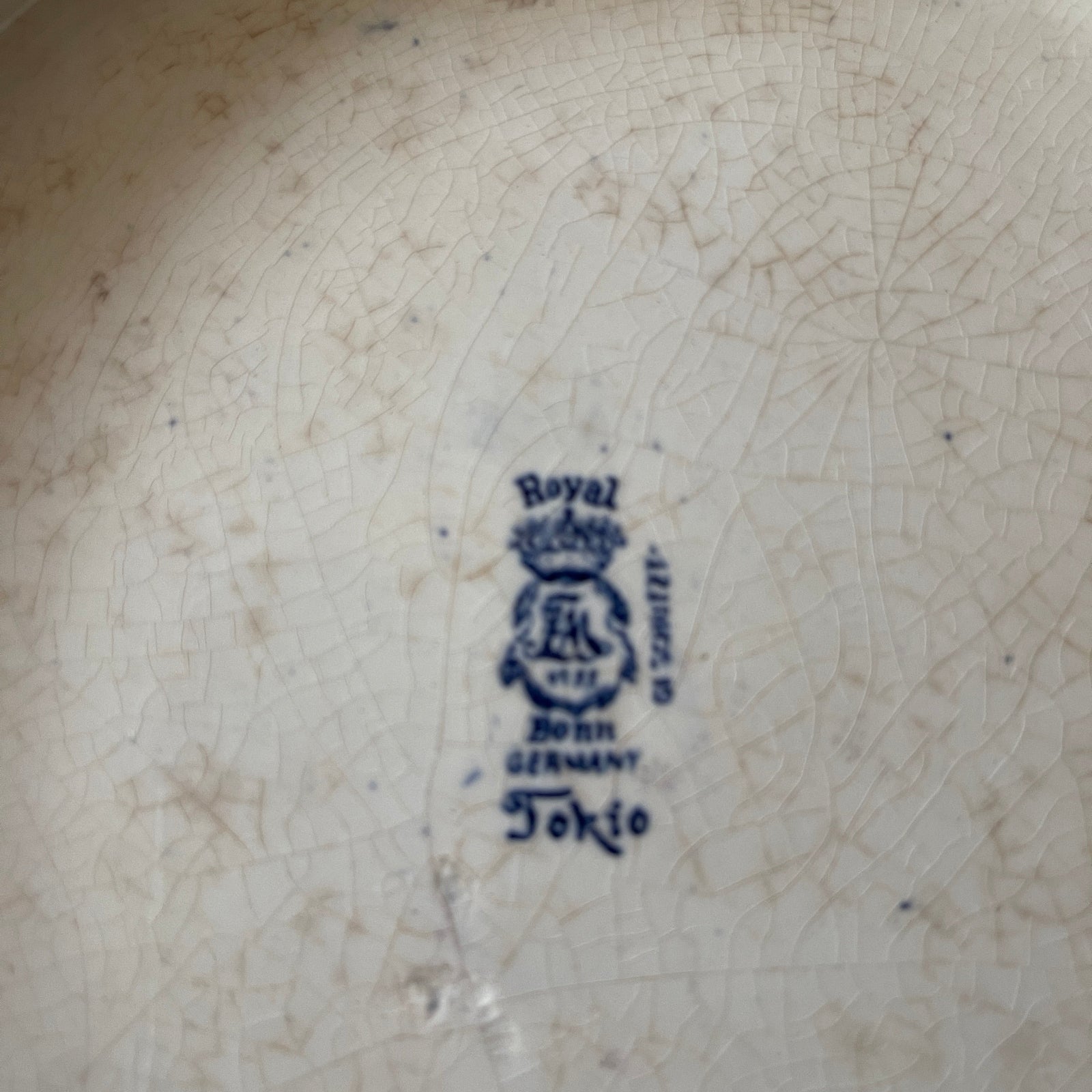 Royal Bonn logo on a ceramic plate with visible wear