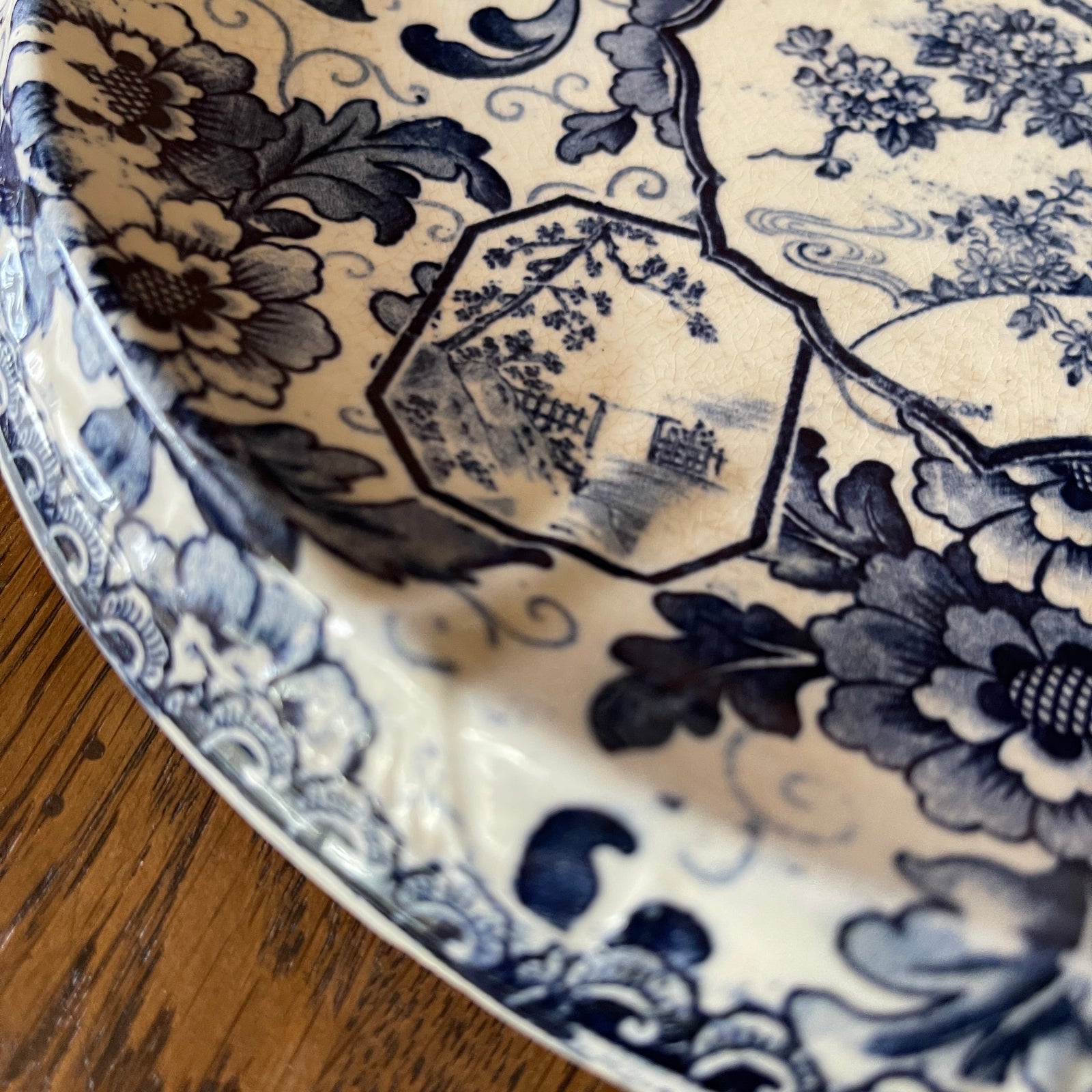 Close-up of a blue and white floral patterned plate on a wooden surface