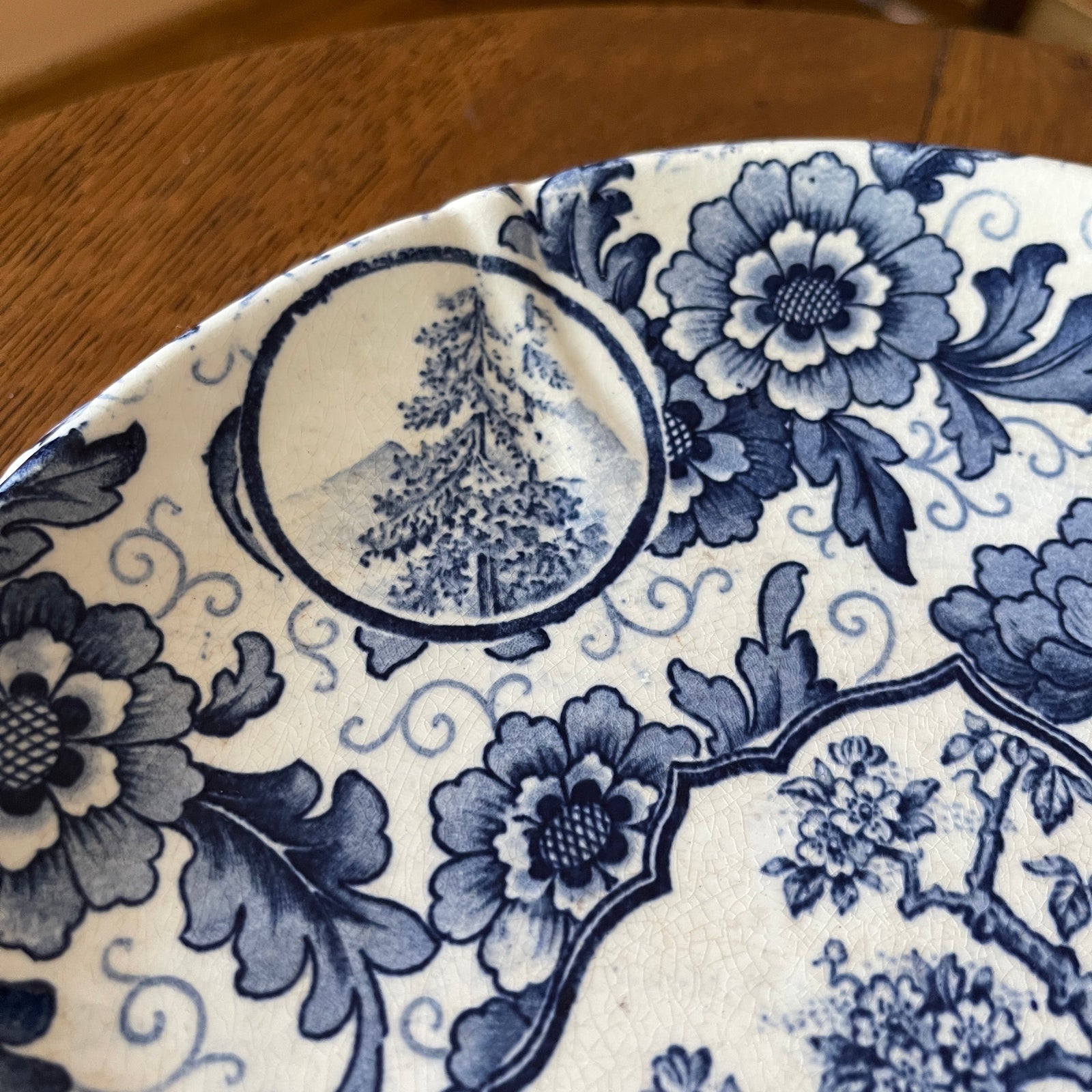 Close-up of a blue and white floral patterned plate on a wooden surface.