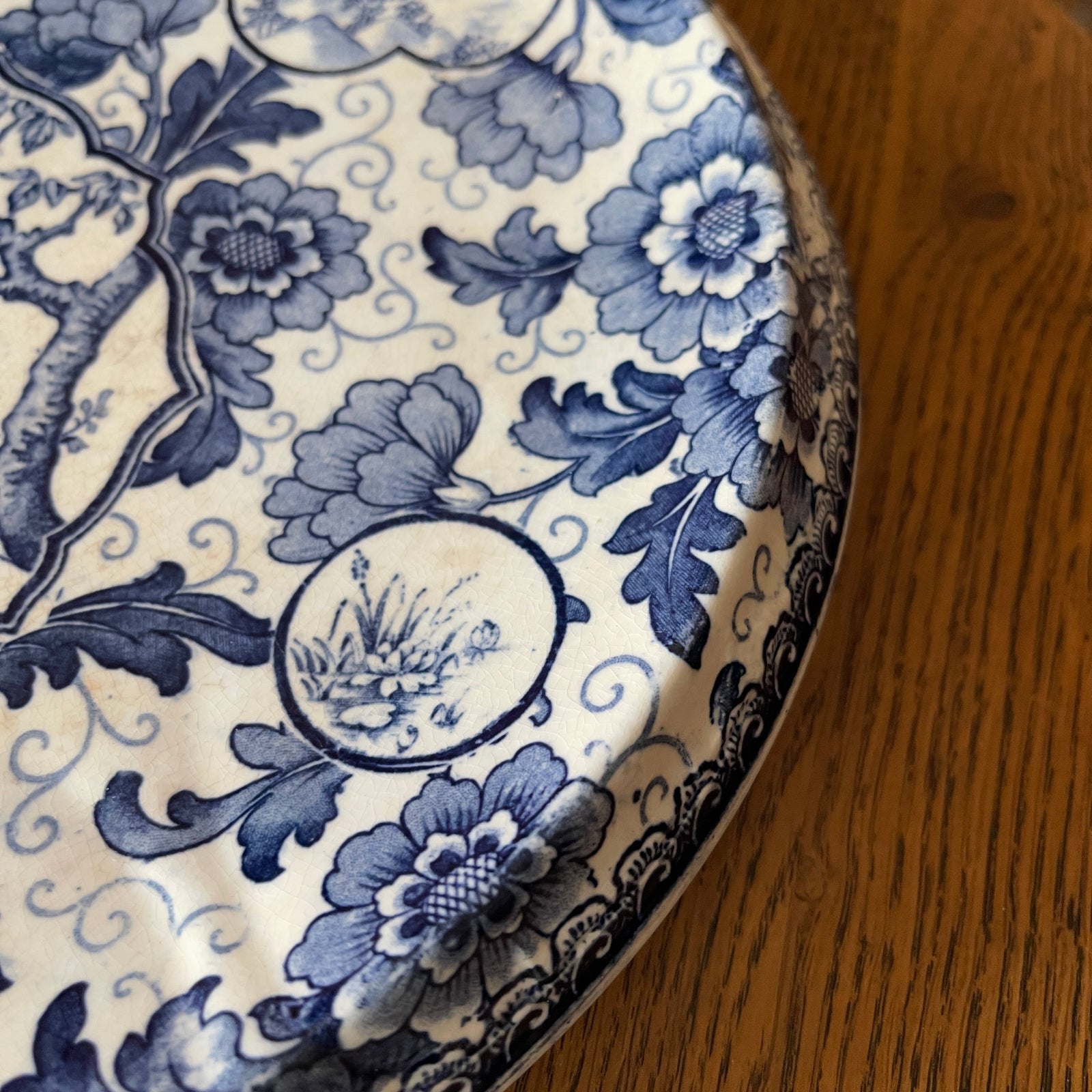 Close-up of a blue and white floral patterned plate on a wooden surface