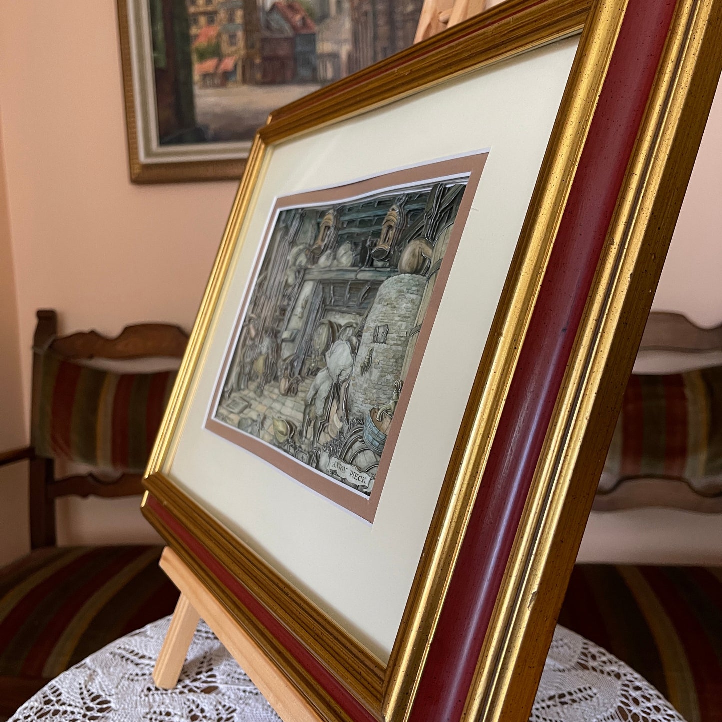 Framed artwork on a small easel with a blurred background