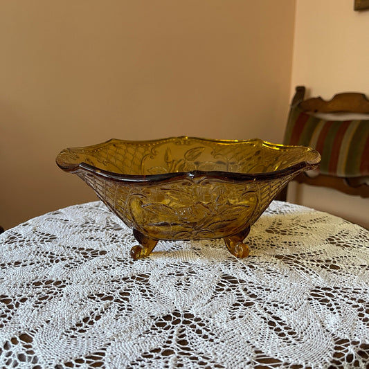 Decorative amber glass bowl on a lace tablecloth with a blurred background