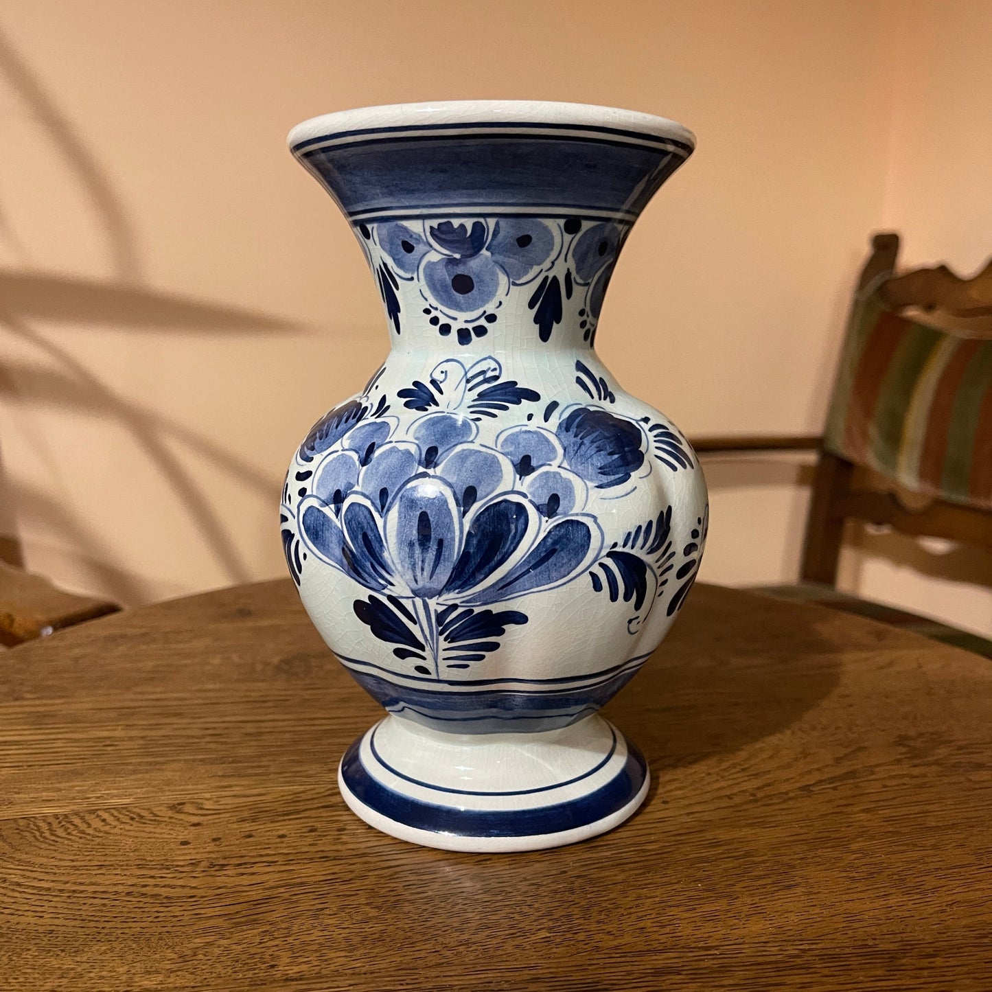 Blue and white ceramic vase on a wooden table with a blurred background