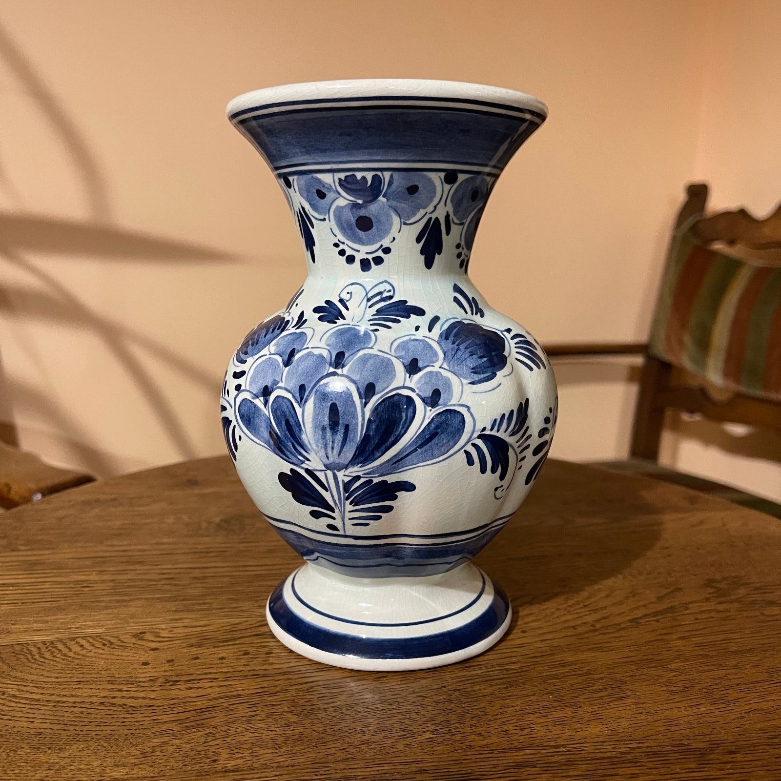 Blue and white ceramic vase on a wooden table with a blurred background