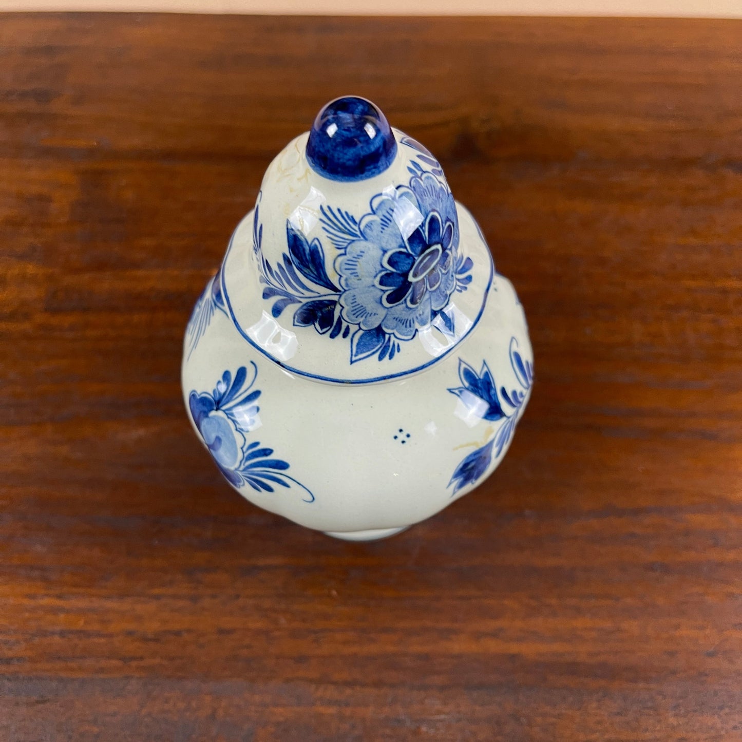 White ceramic vase with blue floral patterns on a wooden surface