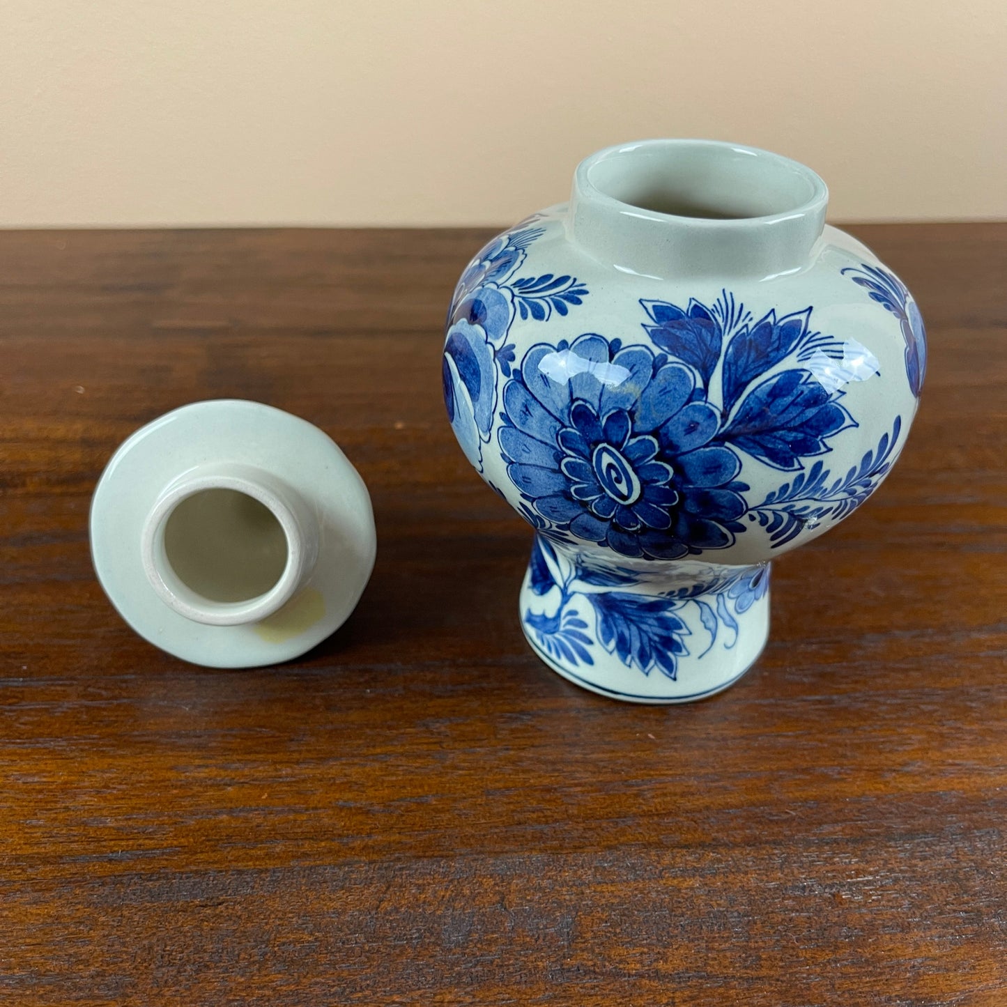 Blue and white floral-patterned ceramic jar on a wooden surface
