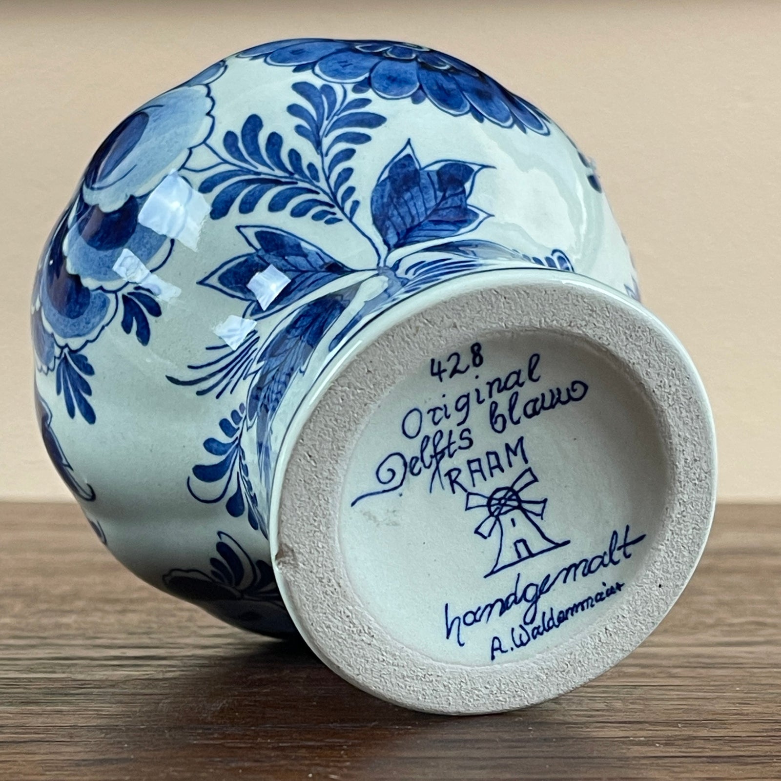 Blue and white ceramic vase with floral patterns on a wooden surface