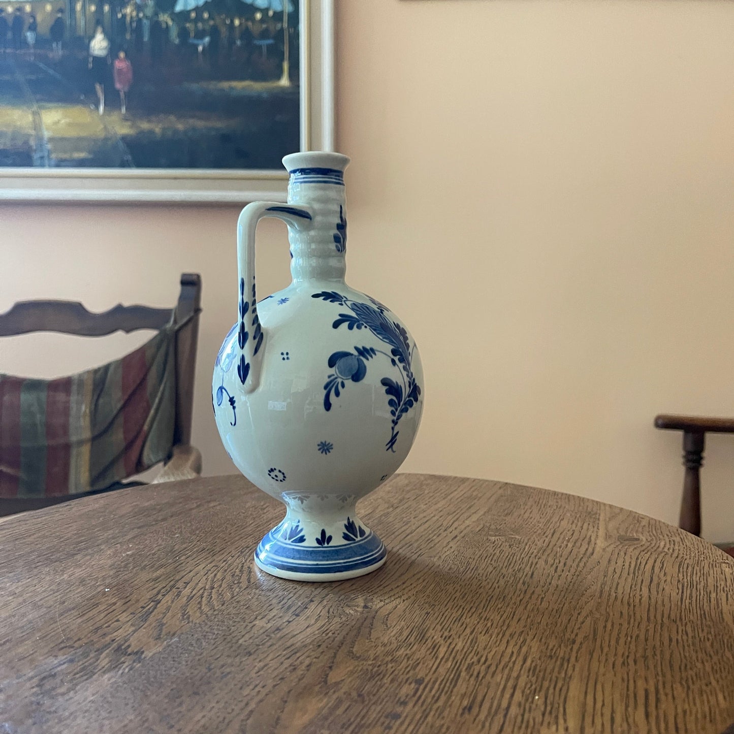 White ceramic vase with blue floral patterns on a wooden table
