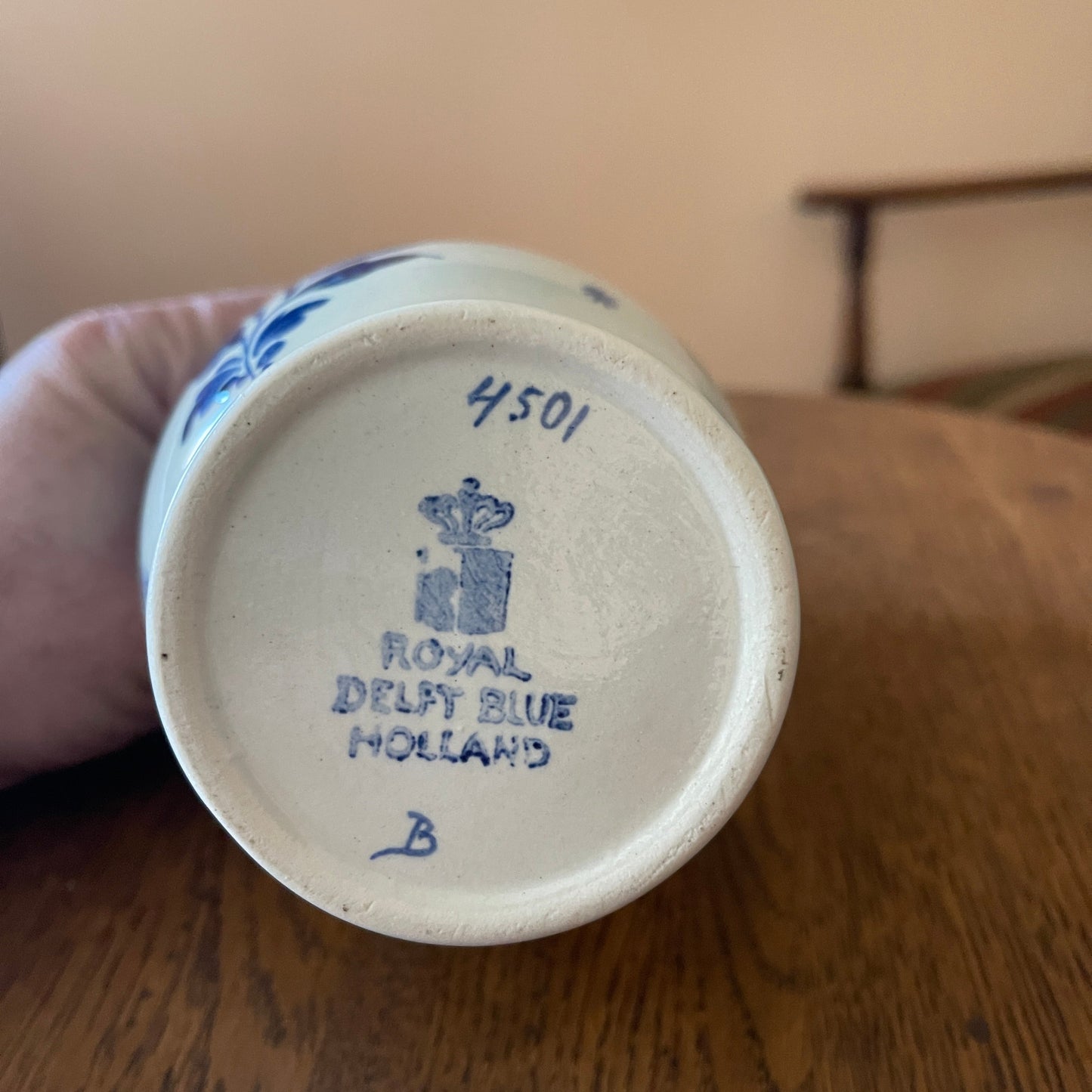 Ceramic vase with 'Royal Delft Blue Holland' branding on a wooden surface