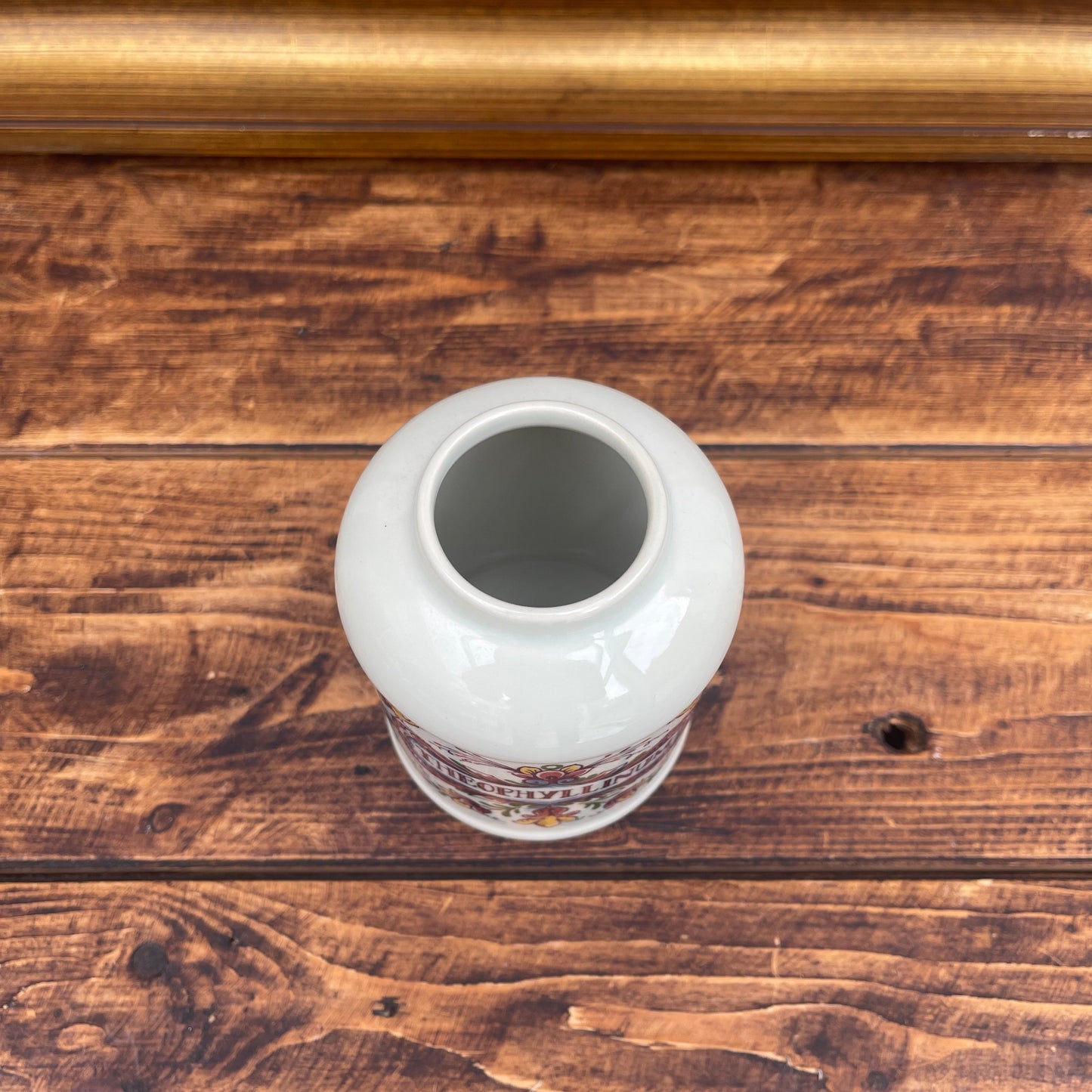 White ceramic vase with decorative patterns on a wooden surface