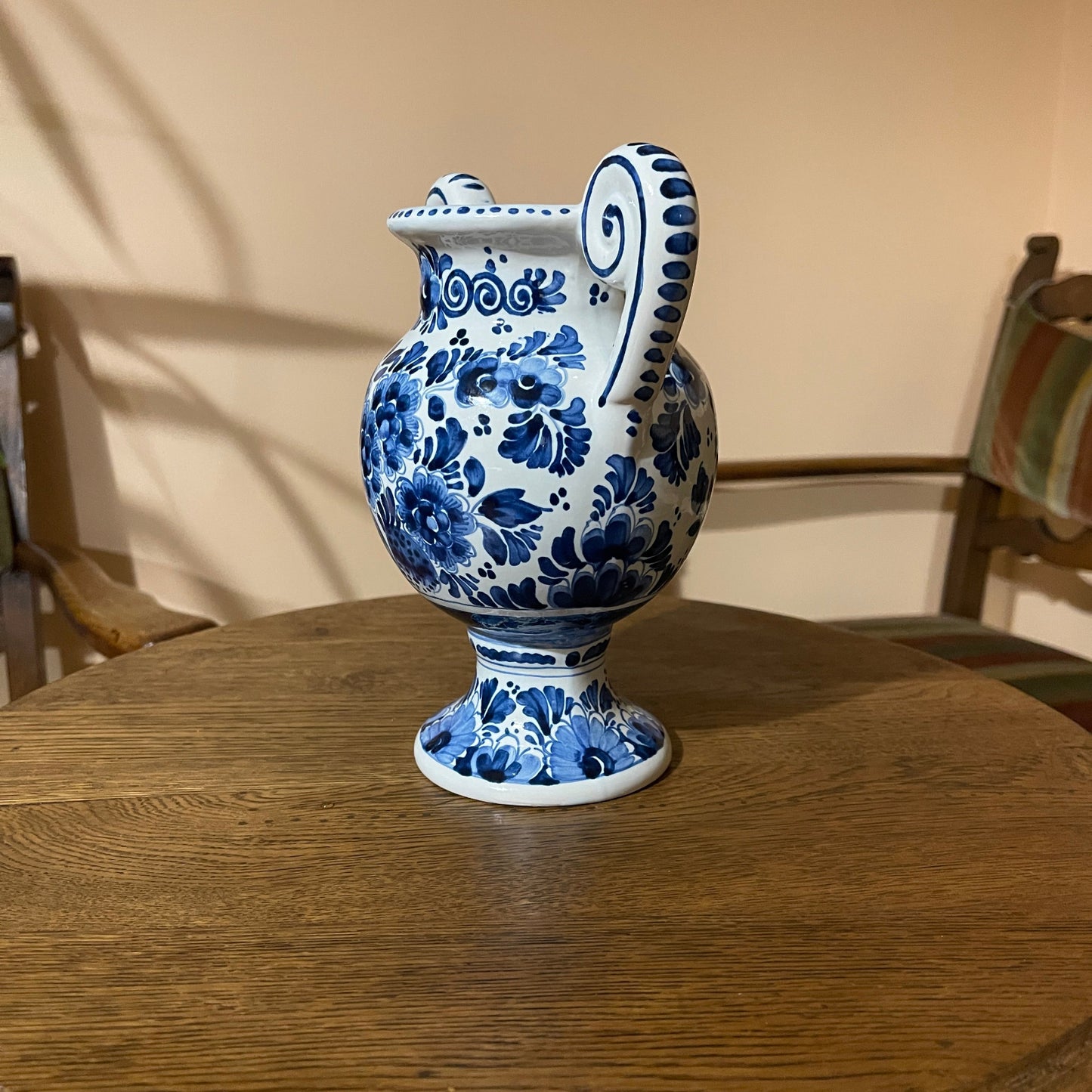 Blue and white floral-patterned ceramic pitcher on a wooden table