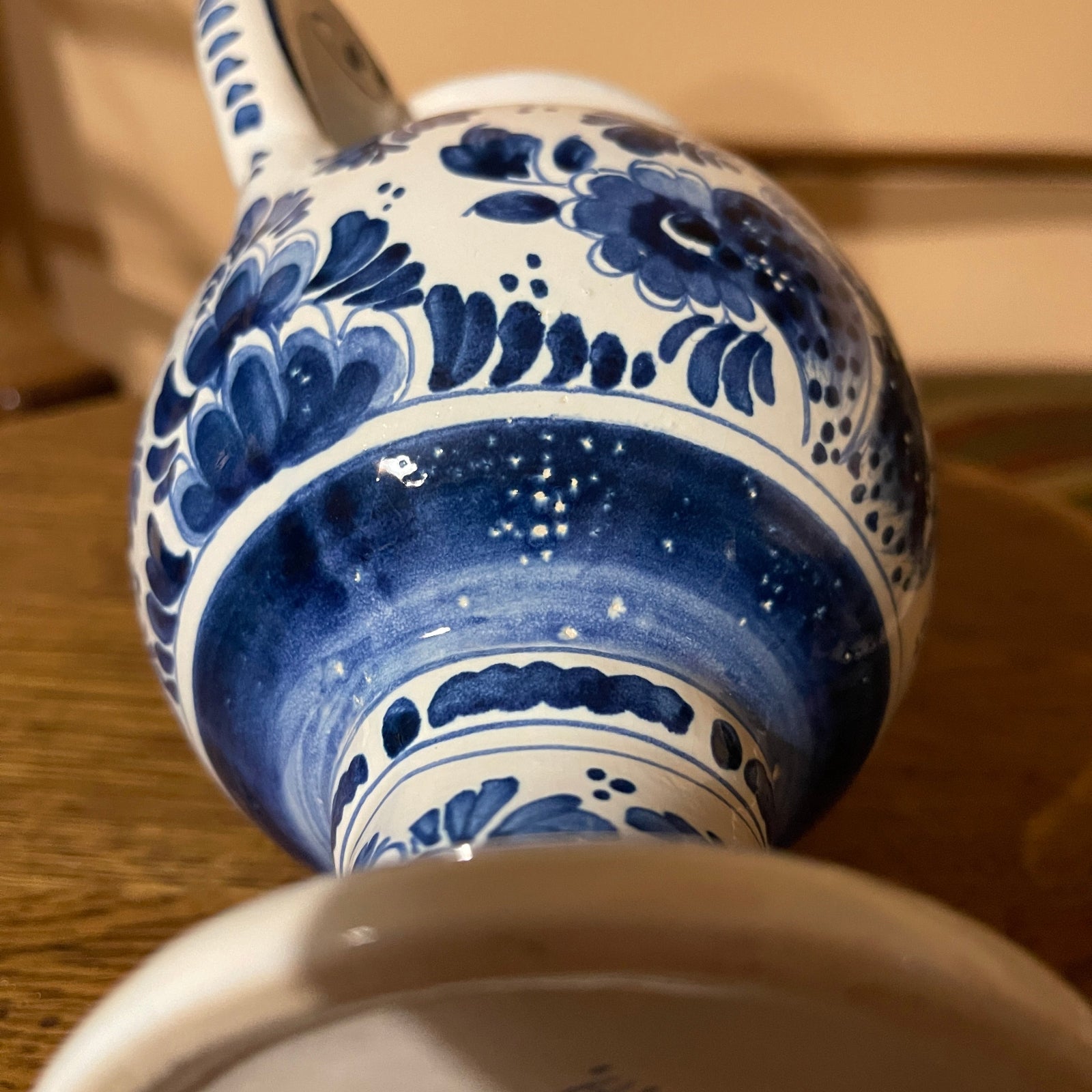 Blue and white ceramic teapot with floral patterns on a wooden surface.