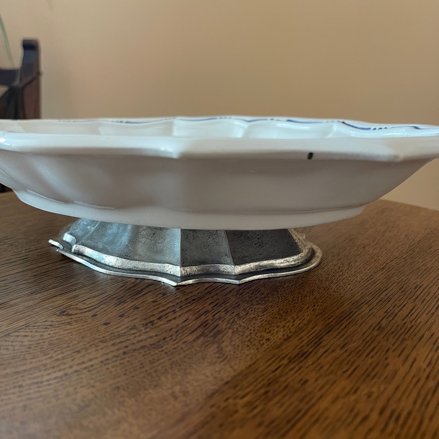 White ceramic dish with silver base on a wooden surface