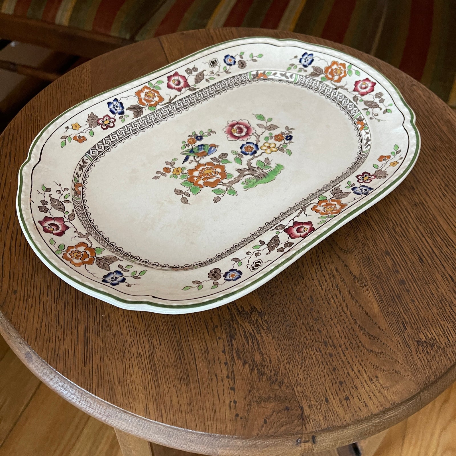 Decorative oval platter with floral patterns on a wooden table