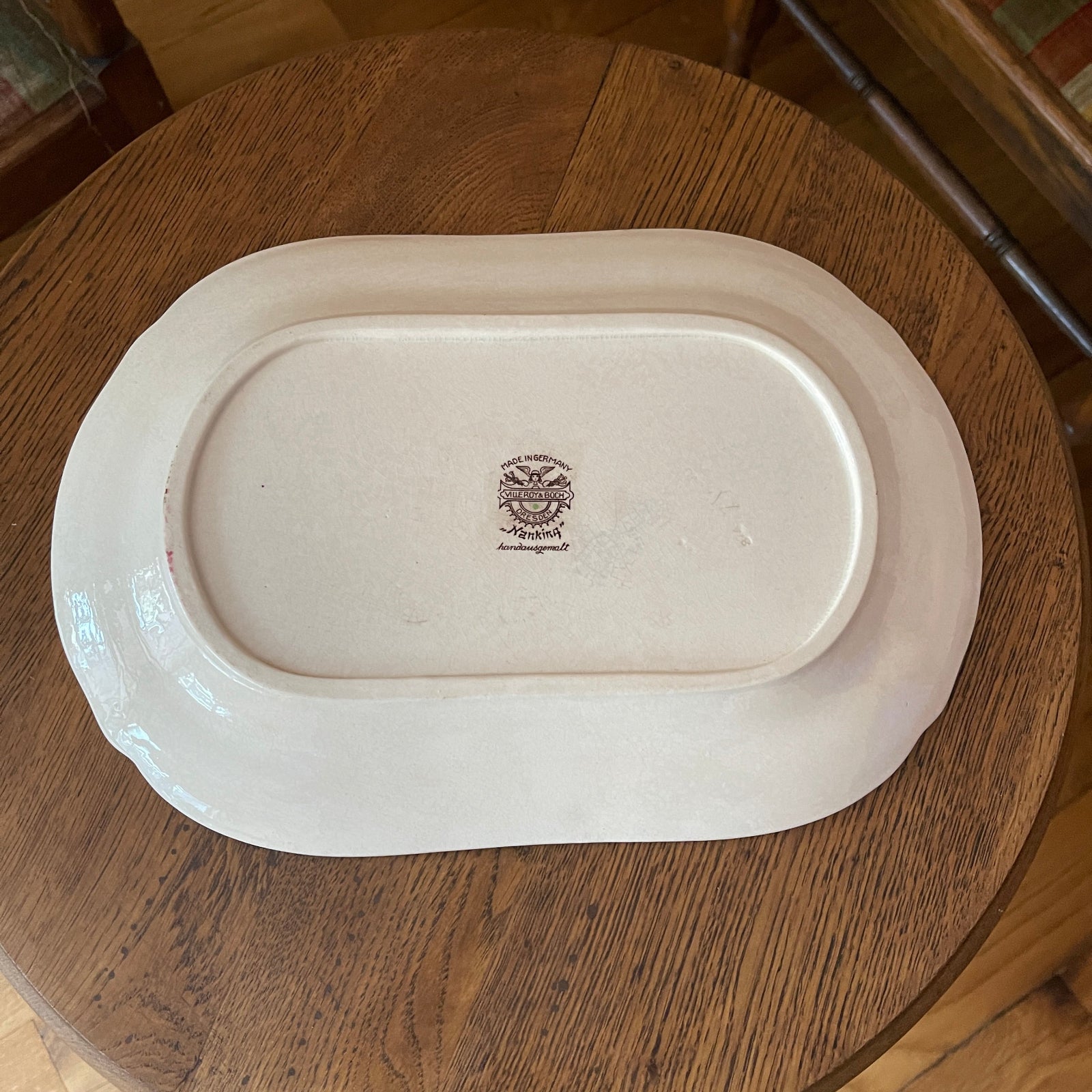 White oval platter with a logo on a wooden surface