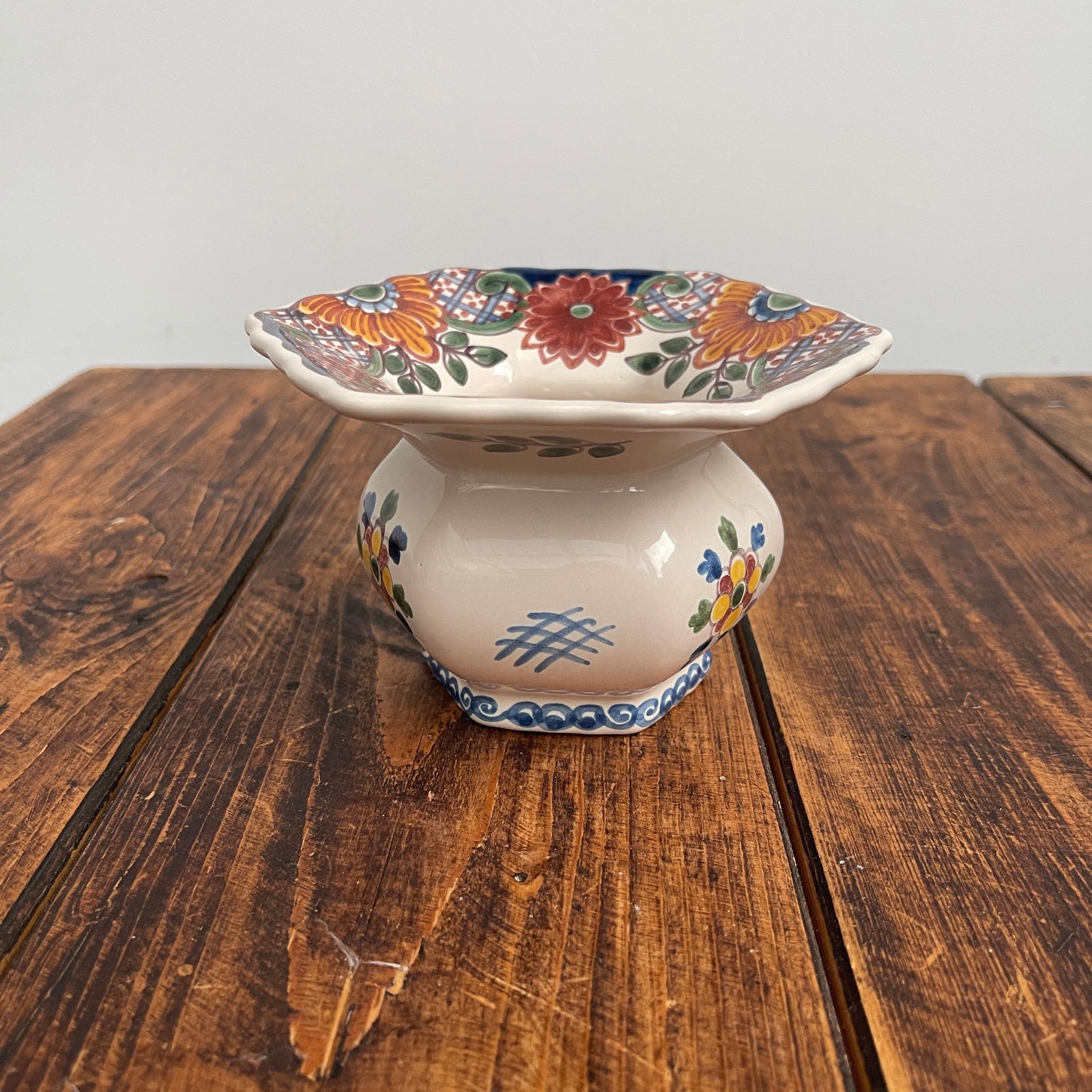 Decorative ceramic dish with floral patterns on a wooden surface