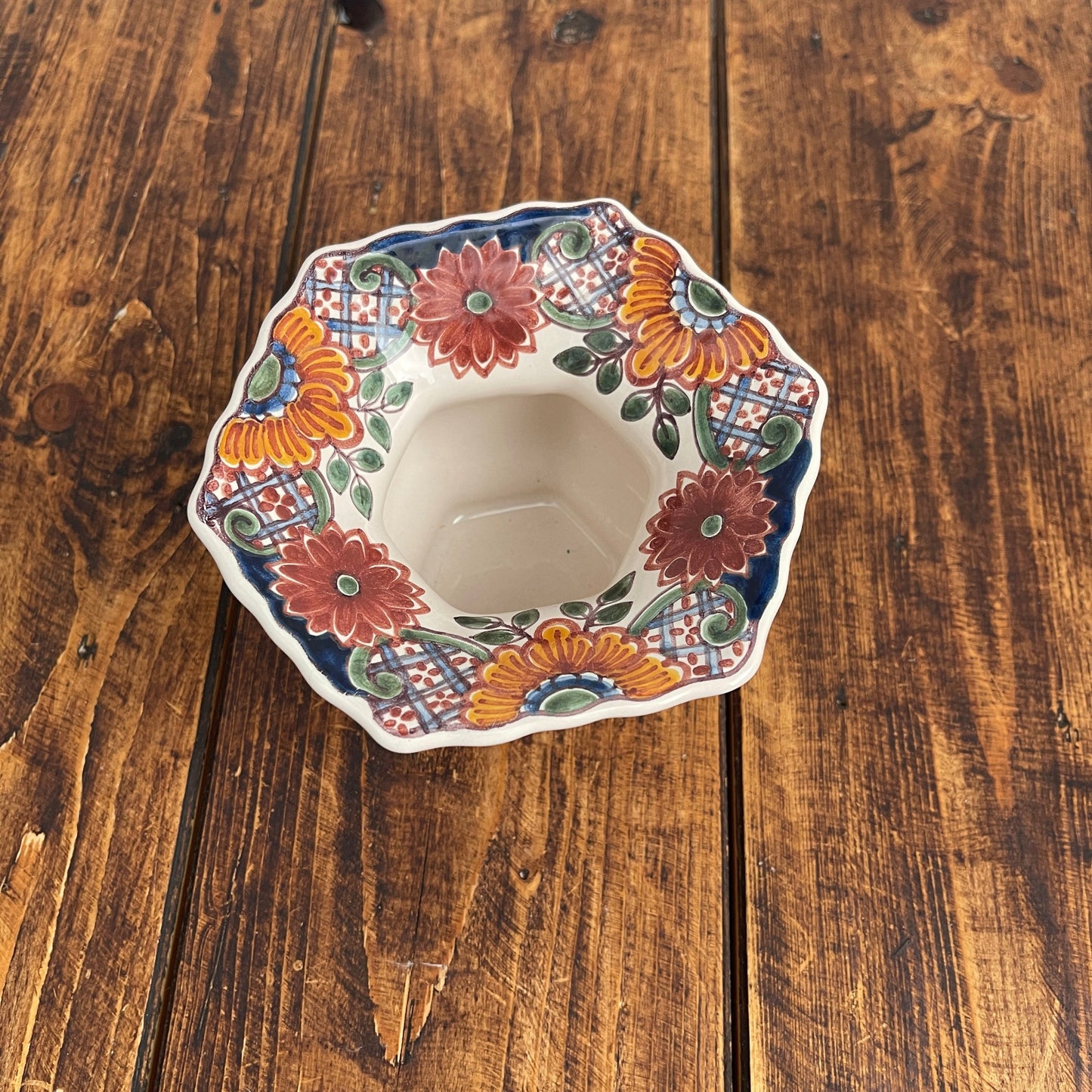 Decorative ceramic bowl with floral patterns on a wooden surface