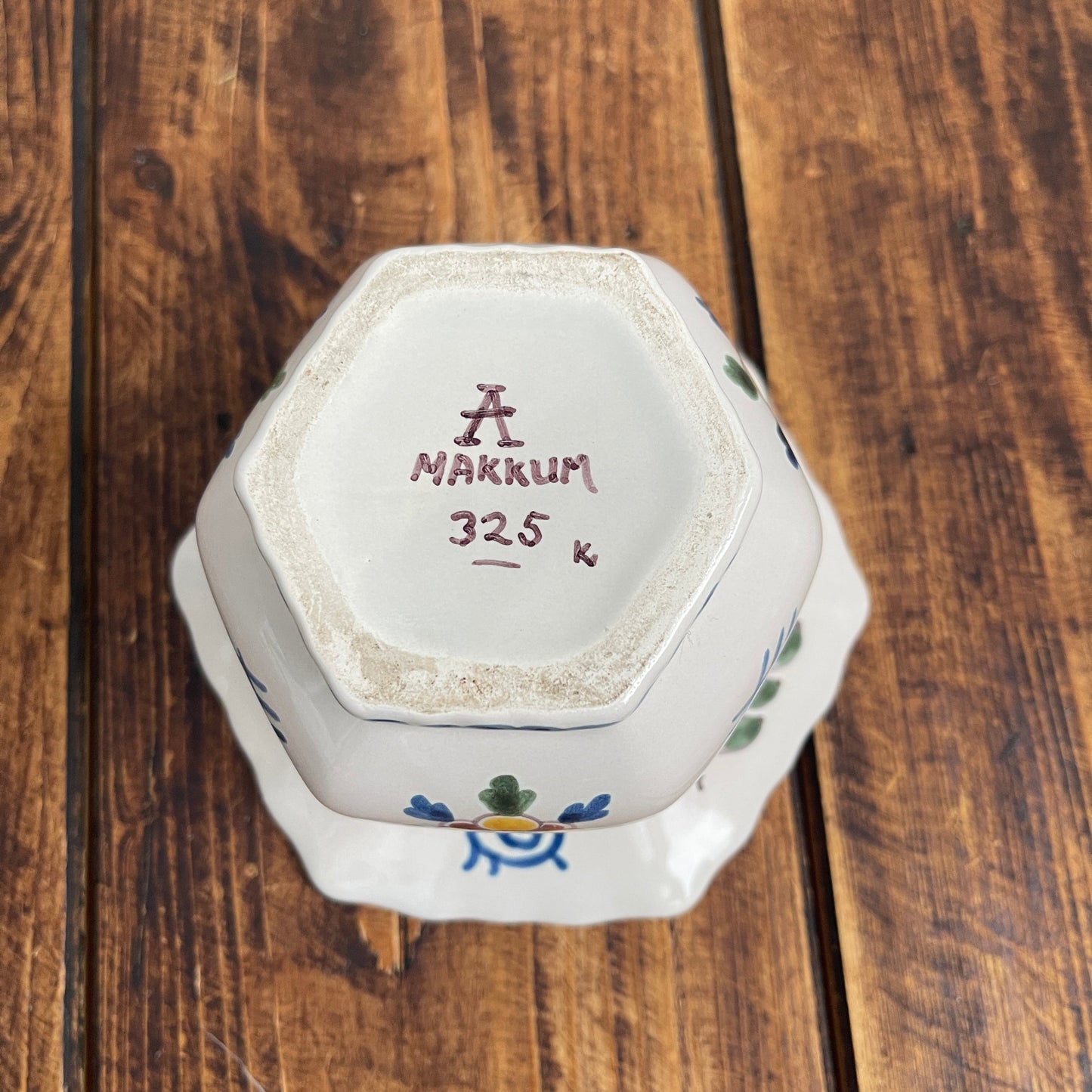 Hexagonal ceramic container with 'MAKKUM' branding on a wooden surface